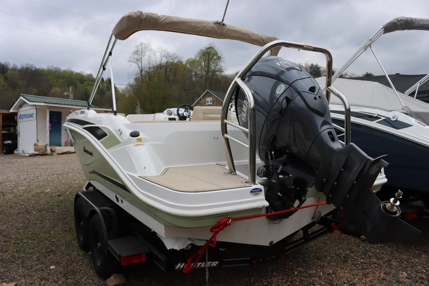 2025 Hurricane SunDeck Sport 205 OB boat with outboard motor on trailer.