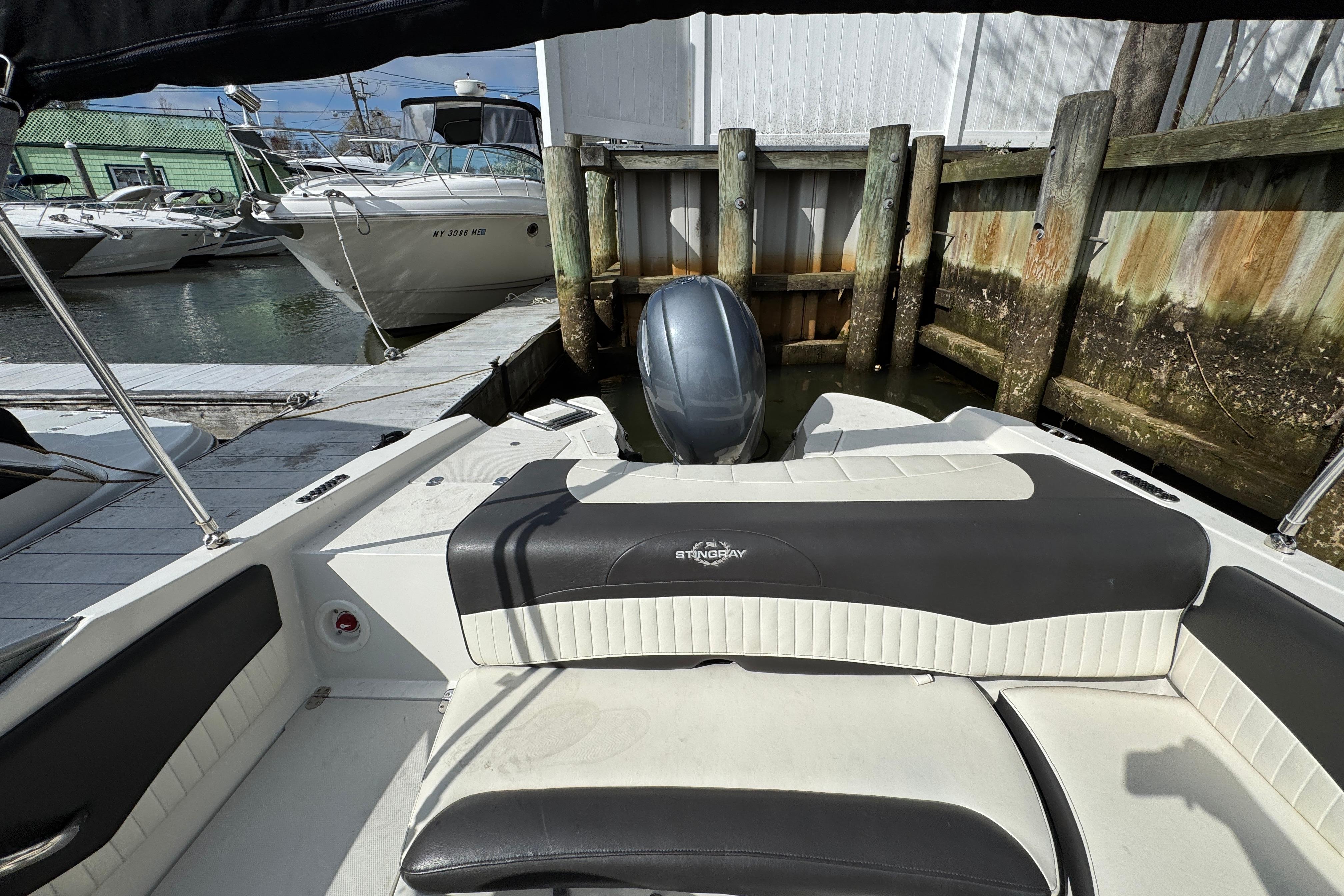 2019 Stingray 204 LR boat docked, featuring sleek seating and outboard motor.