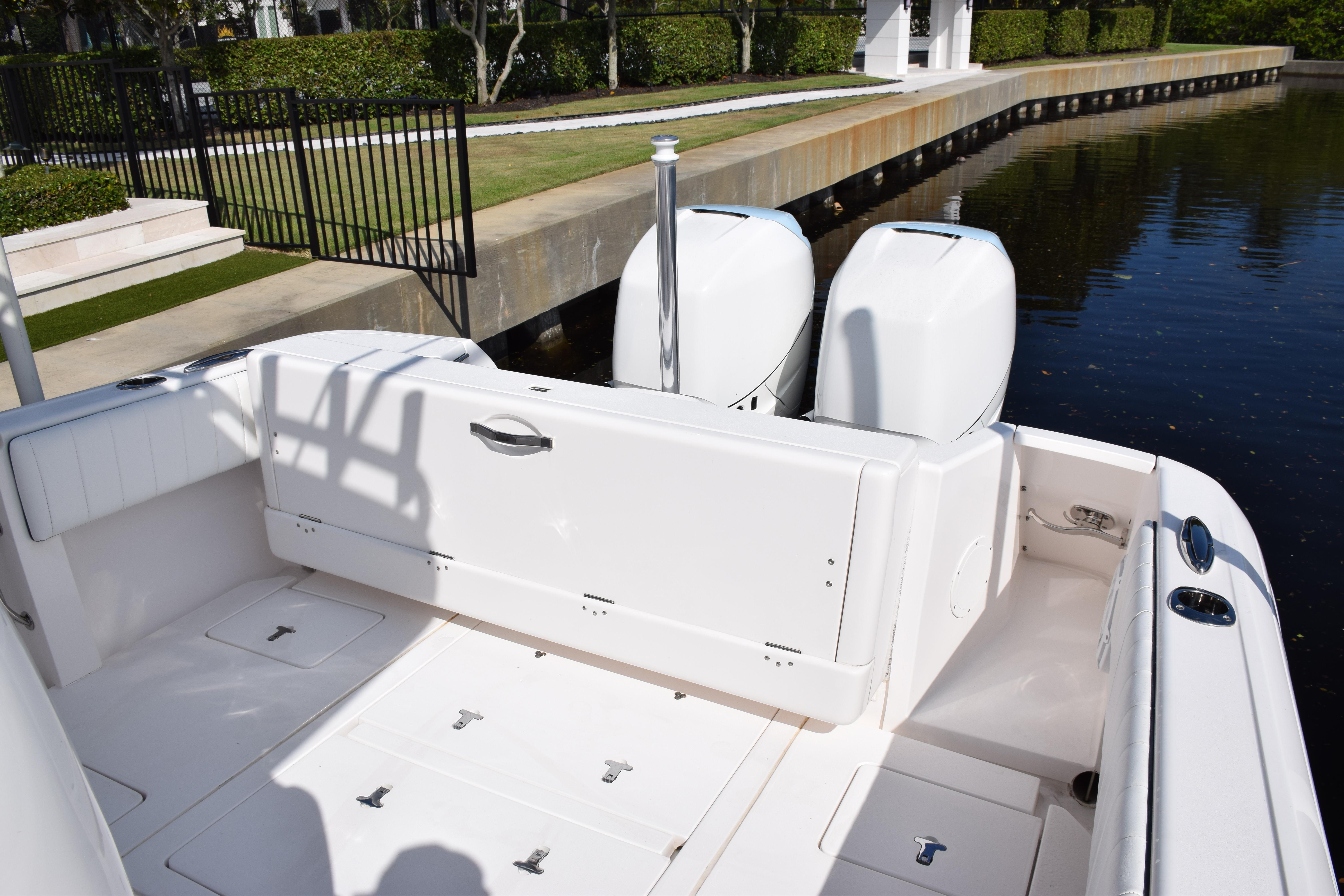 2017 Intrepid 327 boat with dual engines docked by a canal.