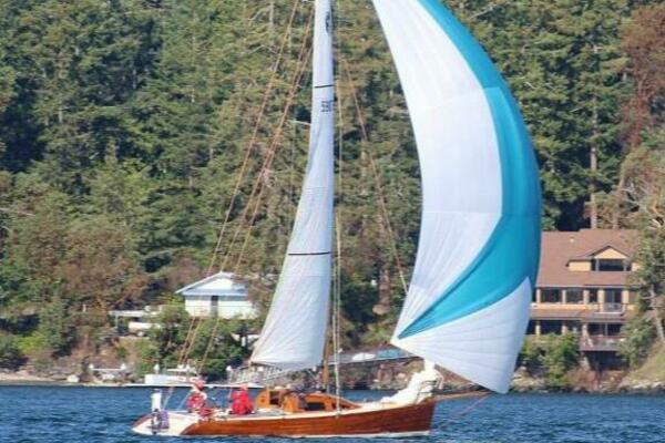 Sailing on a Custom 30 Performance Sloop, 1997, near forested shoreline.