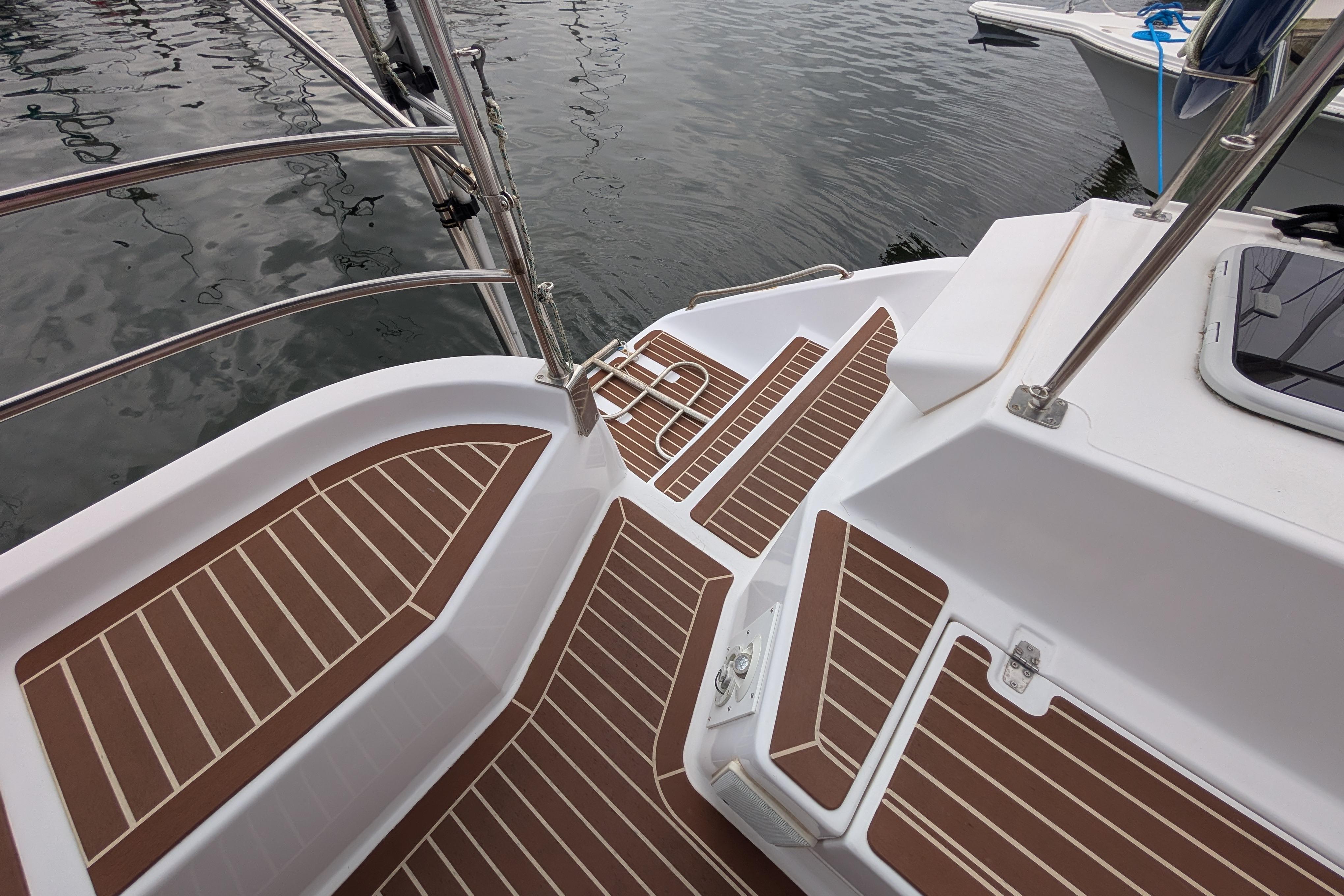 Deck of 1999 Island Spirit 37 sailboat with teak-style flooring, docked at marina.