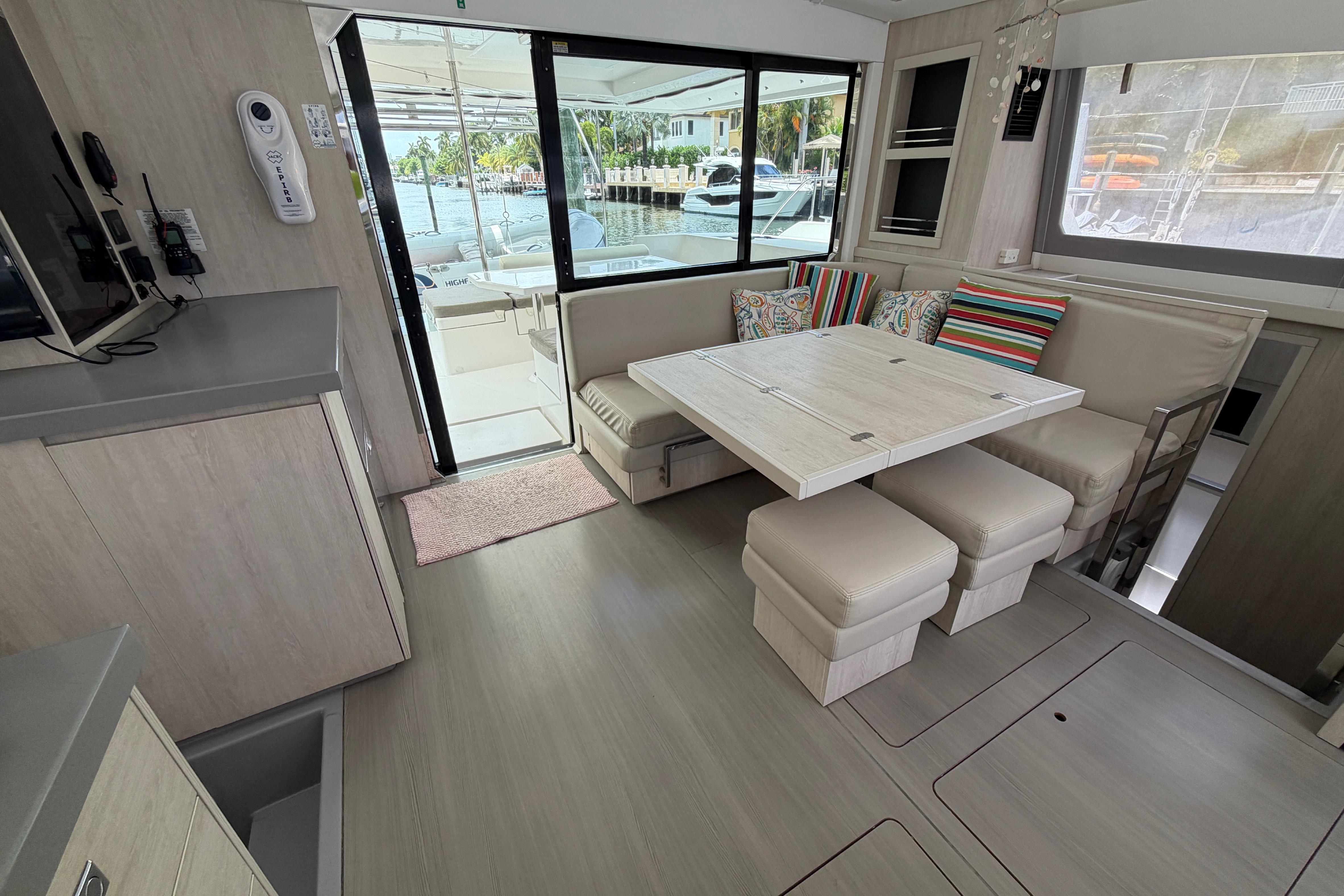 Interior of a 2020 Leopard 40 catamaran with modern dining area and colorful cushions.