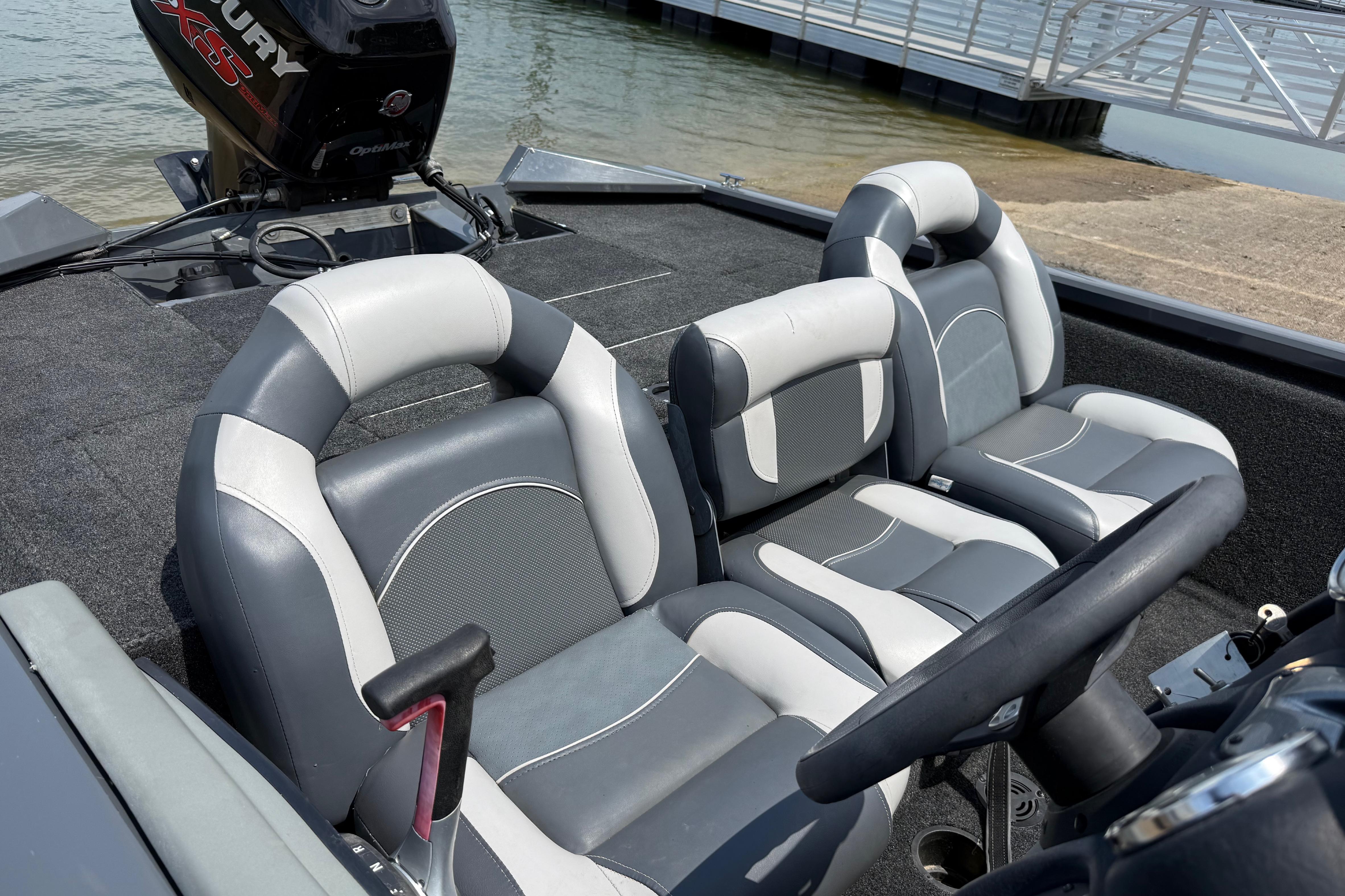 2015 Tracker Pro Team 190 TX boat interior with gray and white seating near a dock.