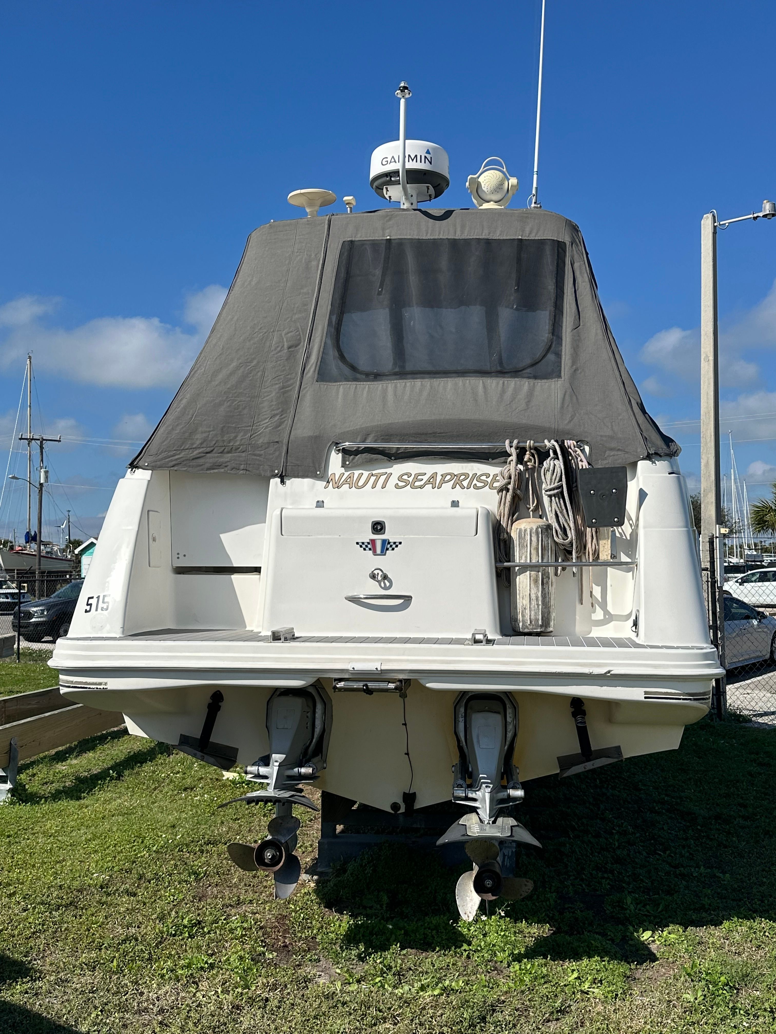 1999 Wellcraft 3000 Martinique boat in harbor, rear view.