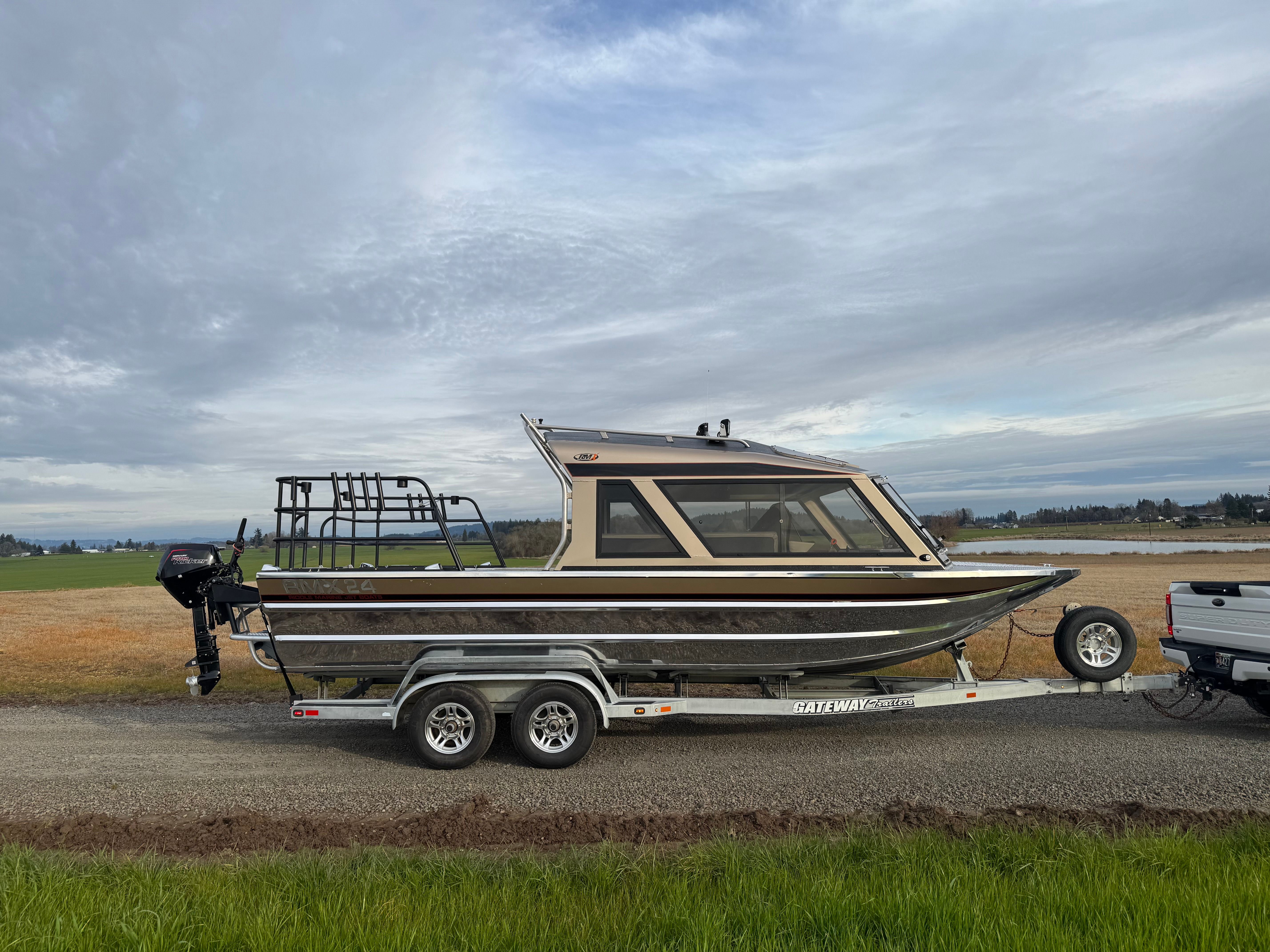Custom RMX 24 boat on trailer, landscape in background.
