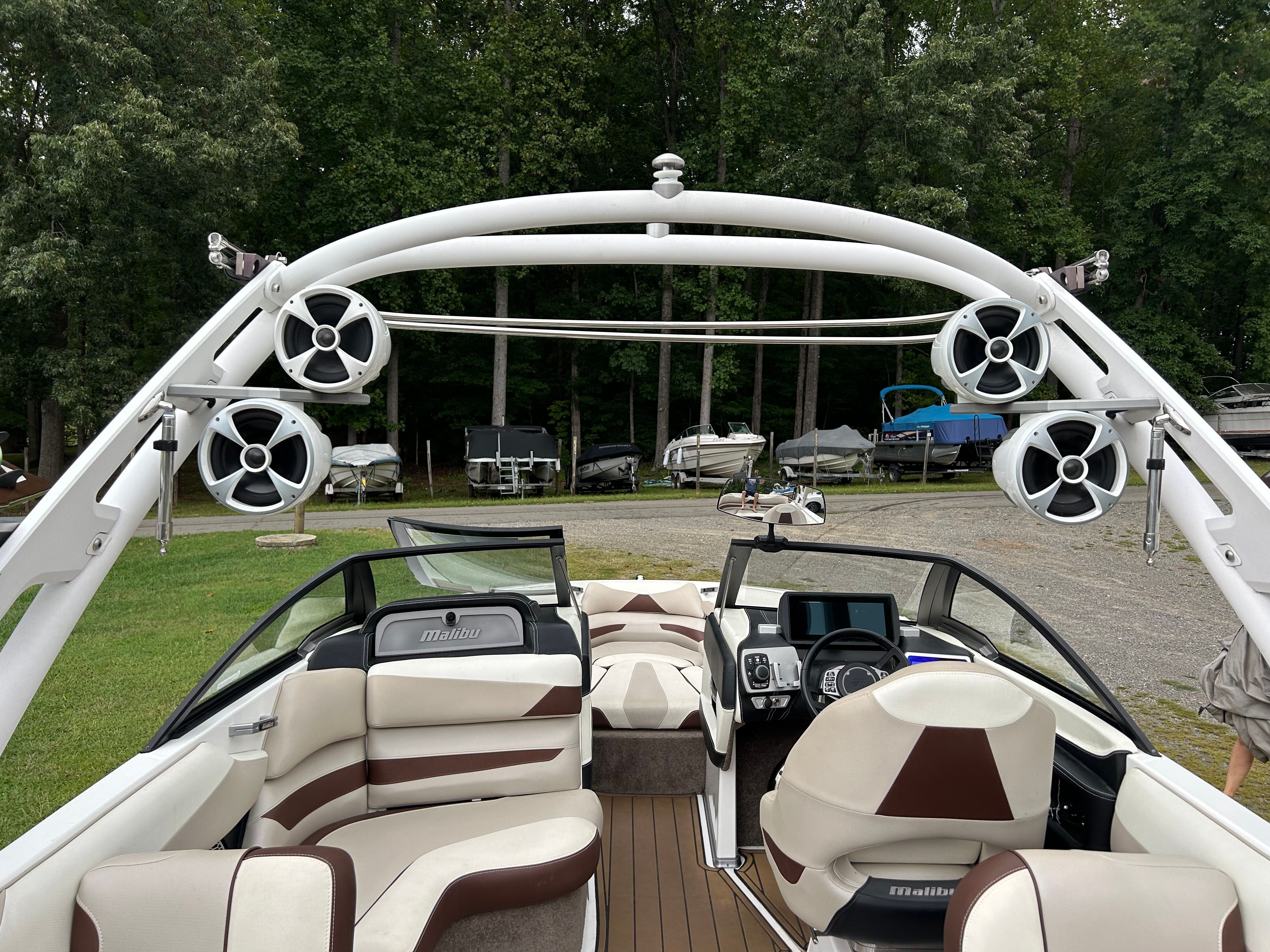 The image shows the interior of a 2016 Malibu Wakesetter 23 LSV with sleek seating and speakers.