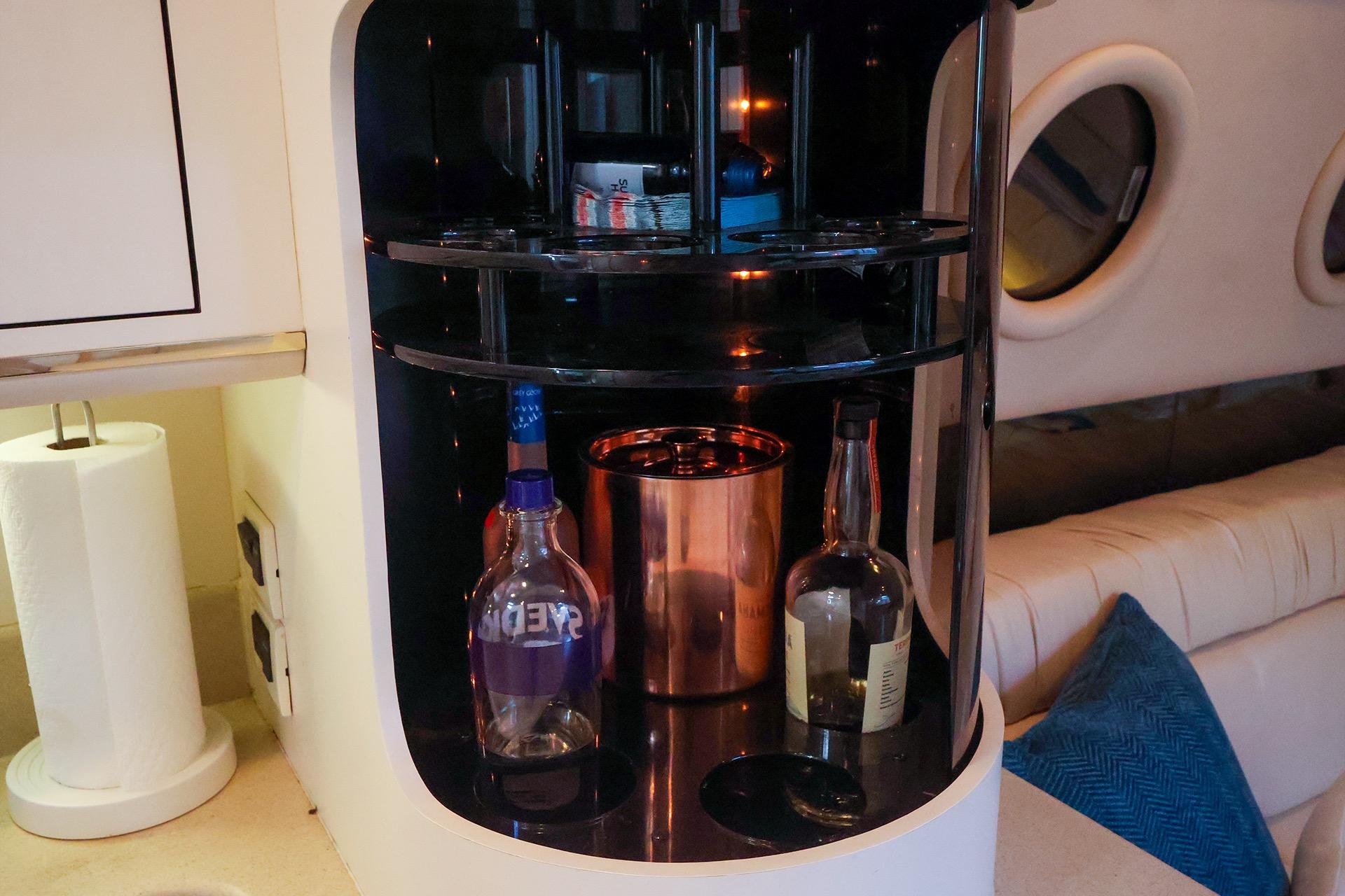 Interior of 1998 Sea Ray 500 Sundancer with a built-in bar and bottles.