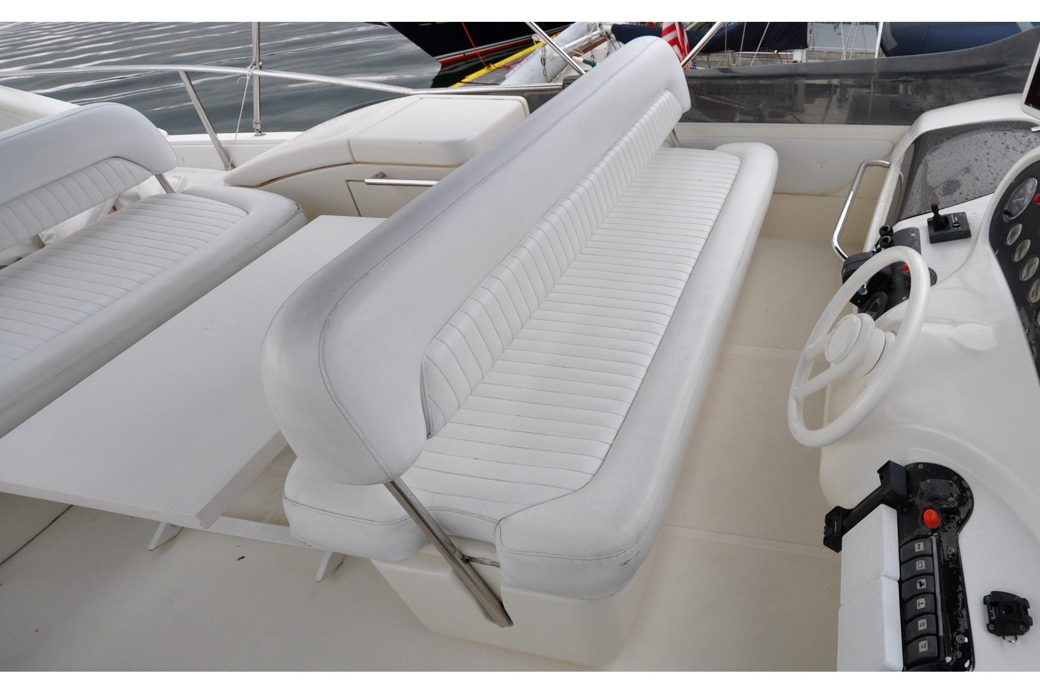 1996 Azimut Cinquantaquattro yacht interior with white seating and steering wheel.