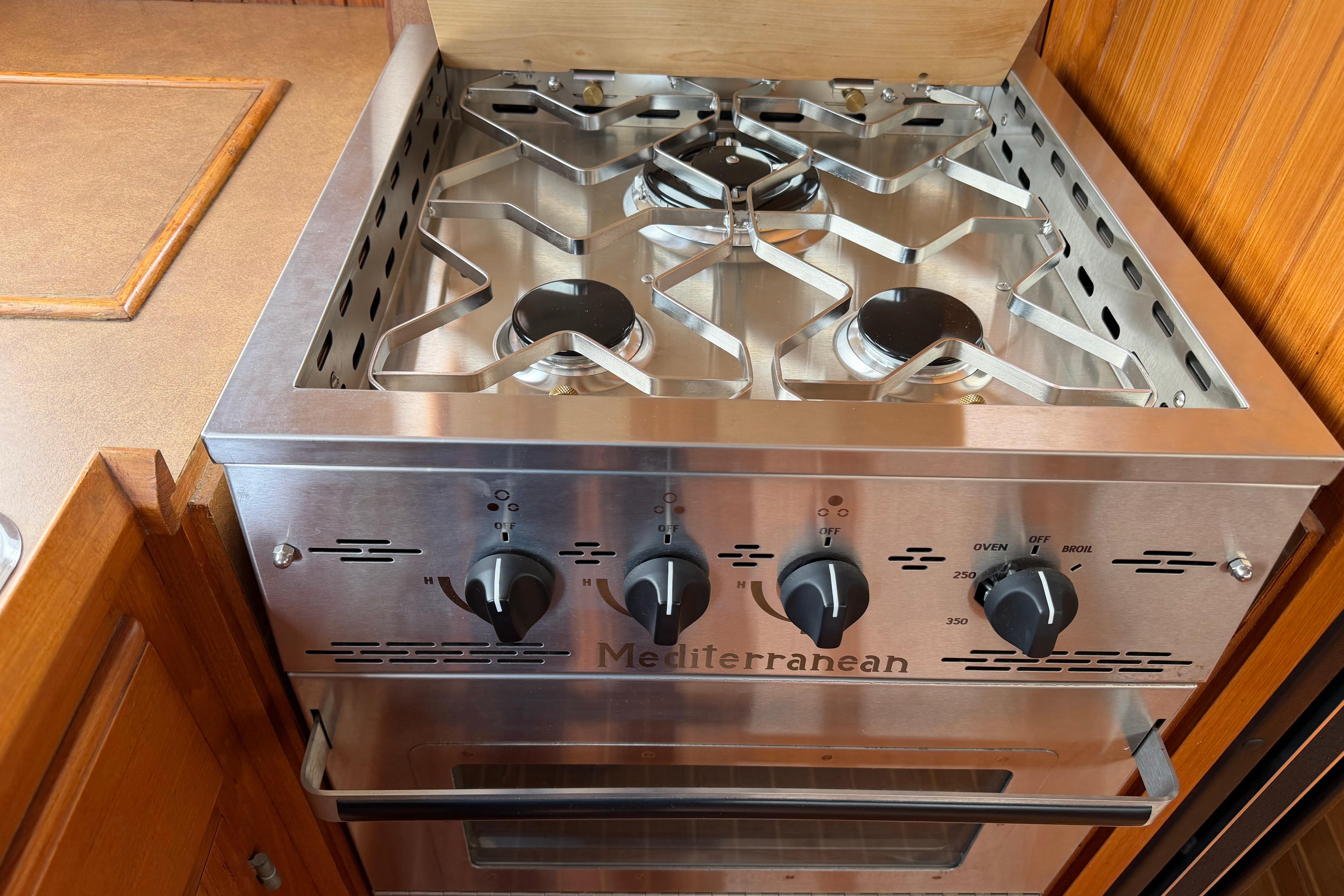 Stainless steel Mediterranean stove with four burners, in a 1988 Monk 36 boat kitchen.