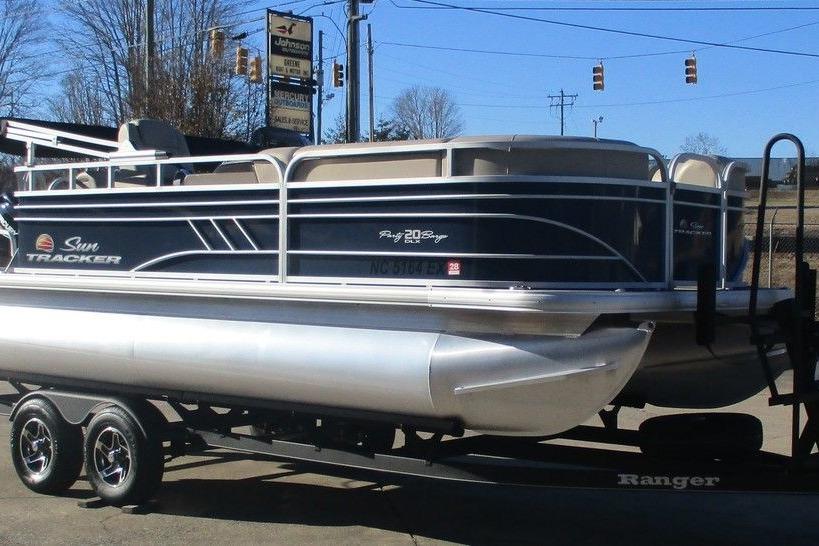 2022 Sun Tracker Party Barge 20 DLX pontoon boat on trailer, parked outdoors.