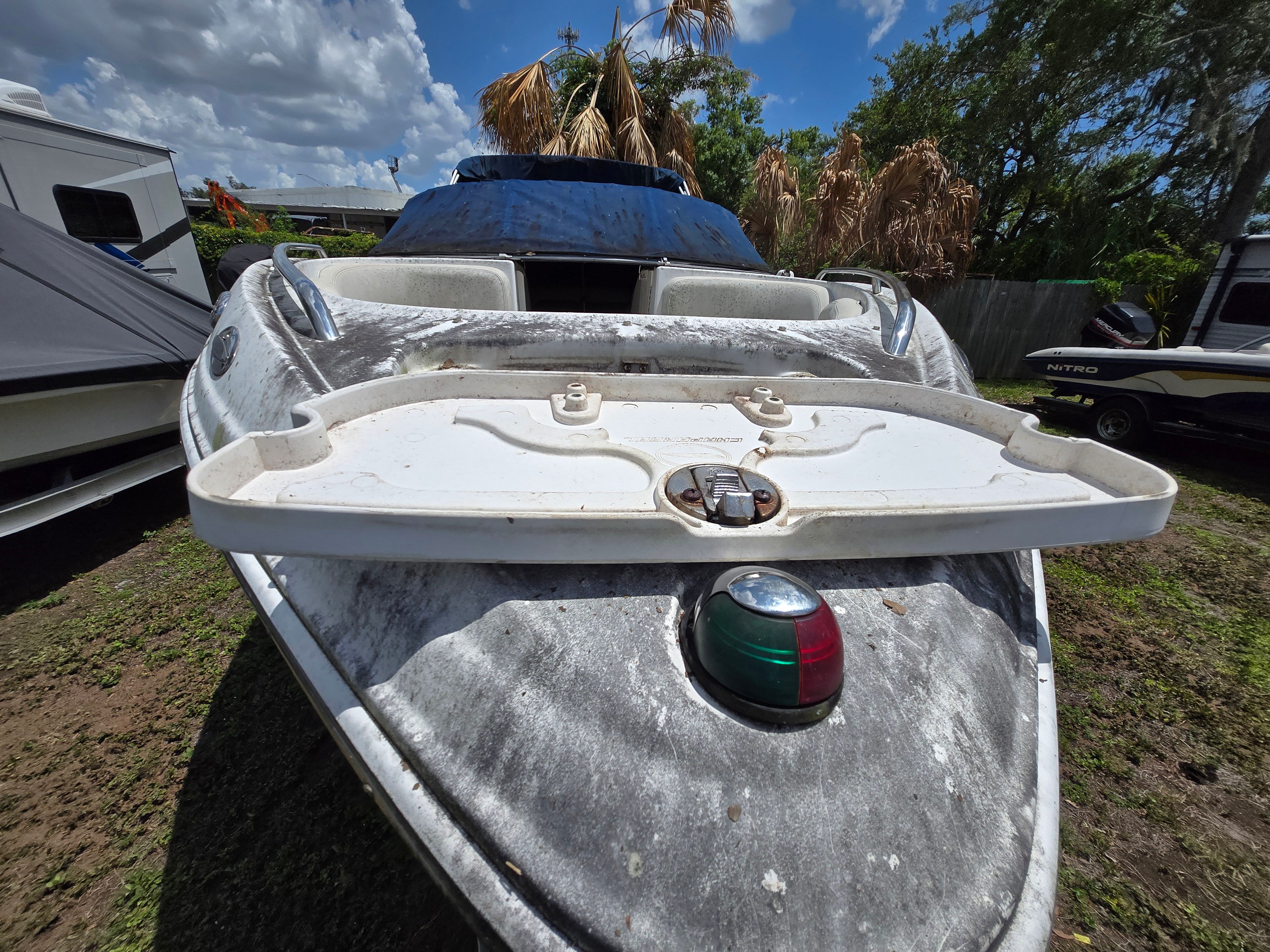 A 2006 Chaparral 220 SSi boat on grassy ground. It appears somewhat weathered.