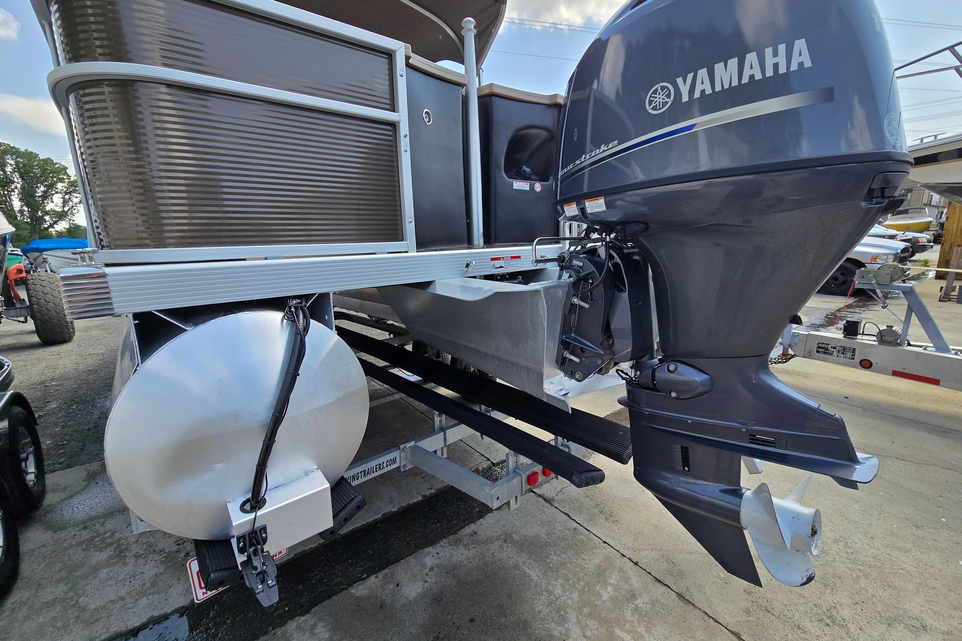2024 Bennington S22 pontoon boat with Yamaha outboard motor, docked on a trailer.