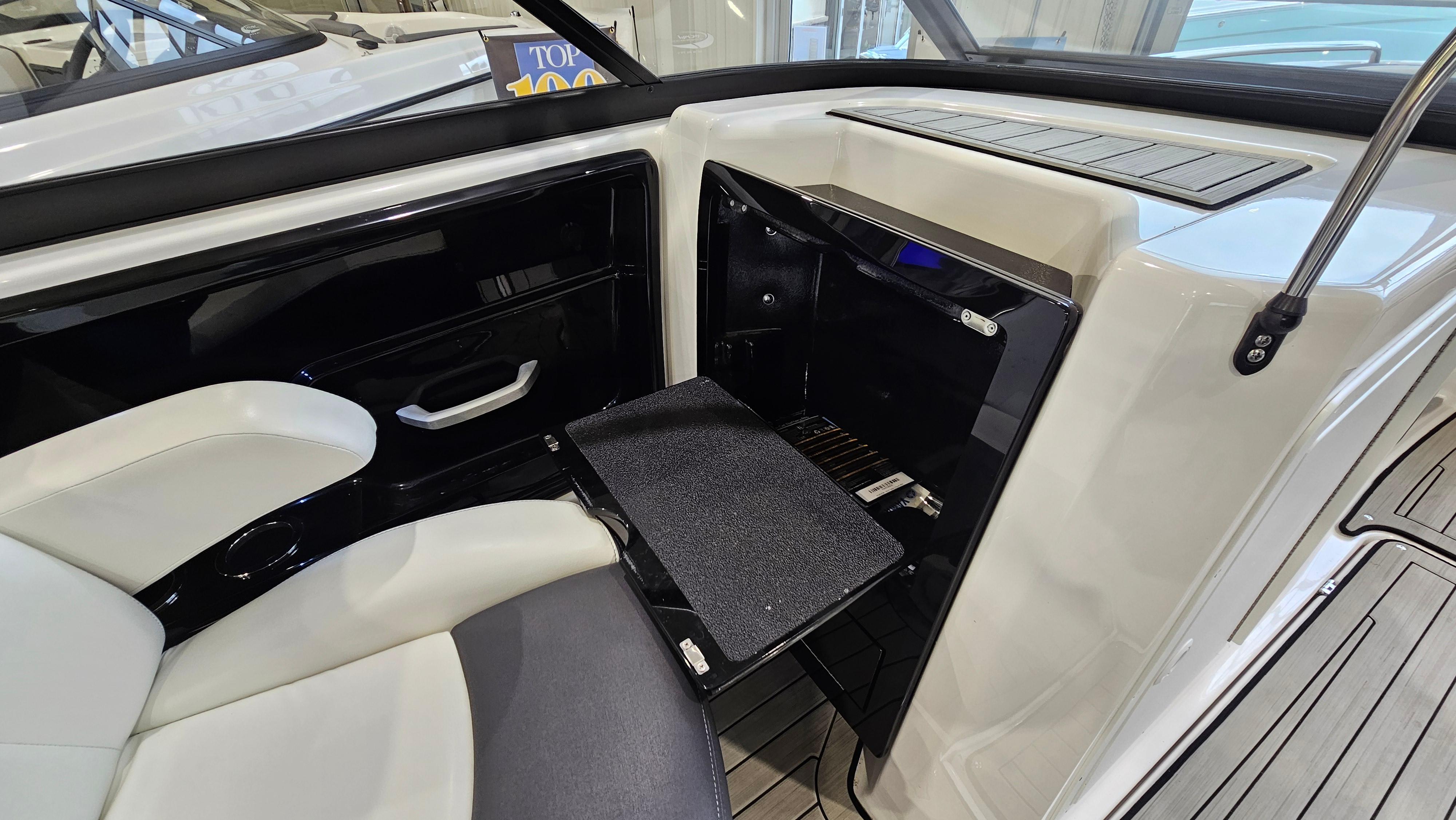 Interior of 2021 Yamaha Boats 212SD, featuring seating and storage compartment.