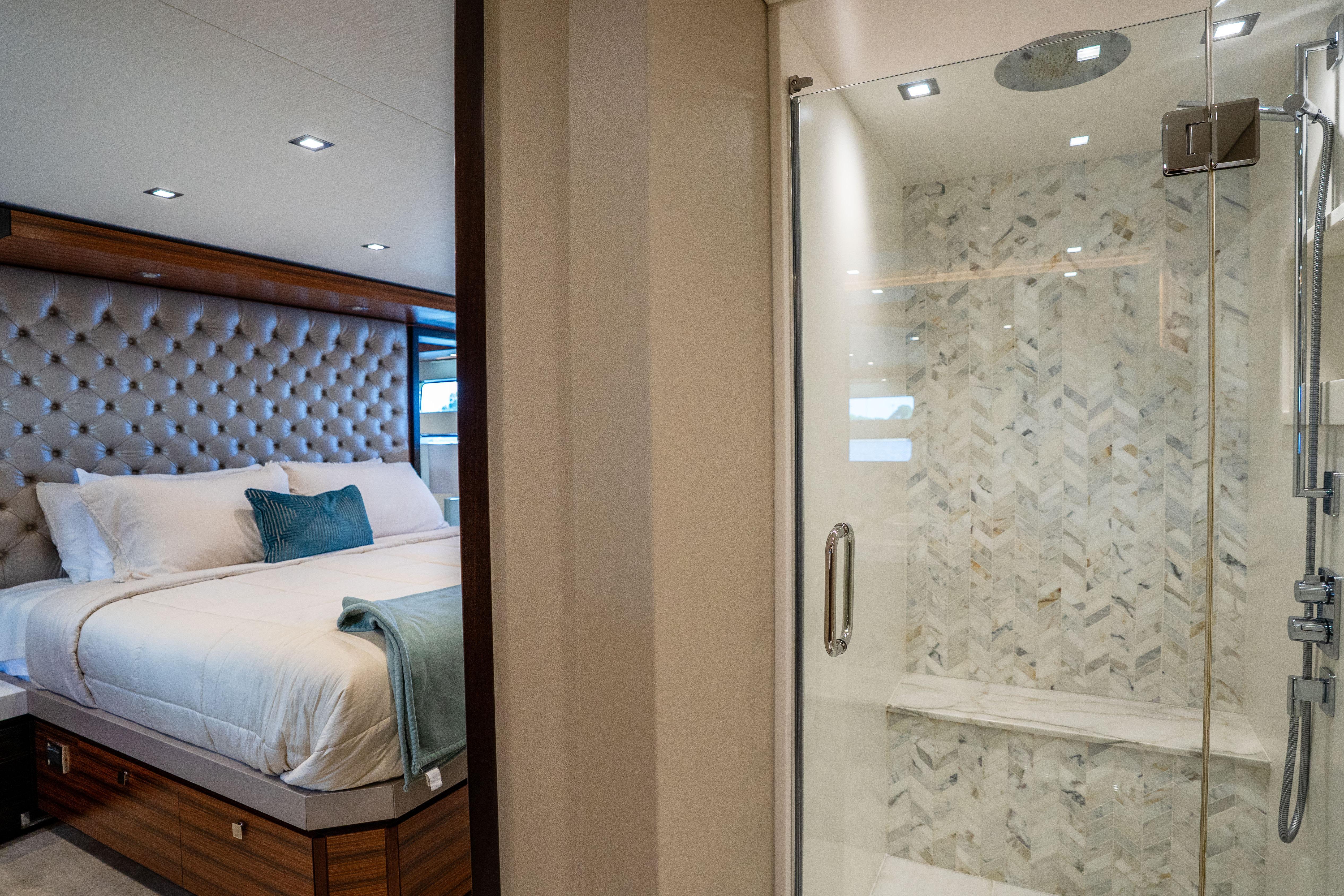 Luxurious bedroom and shower in 2021 Hatteras M75 Panacera yacht, featuring elegant design.