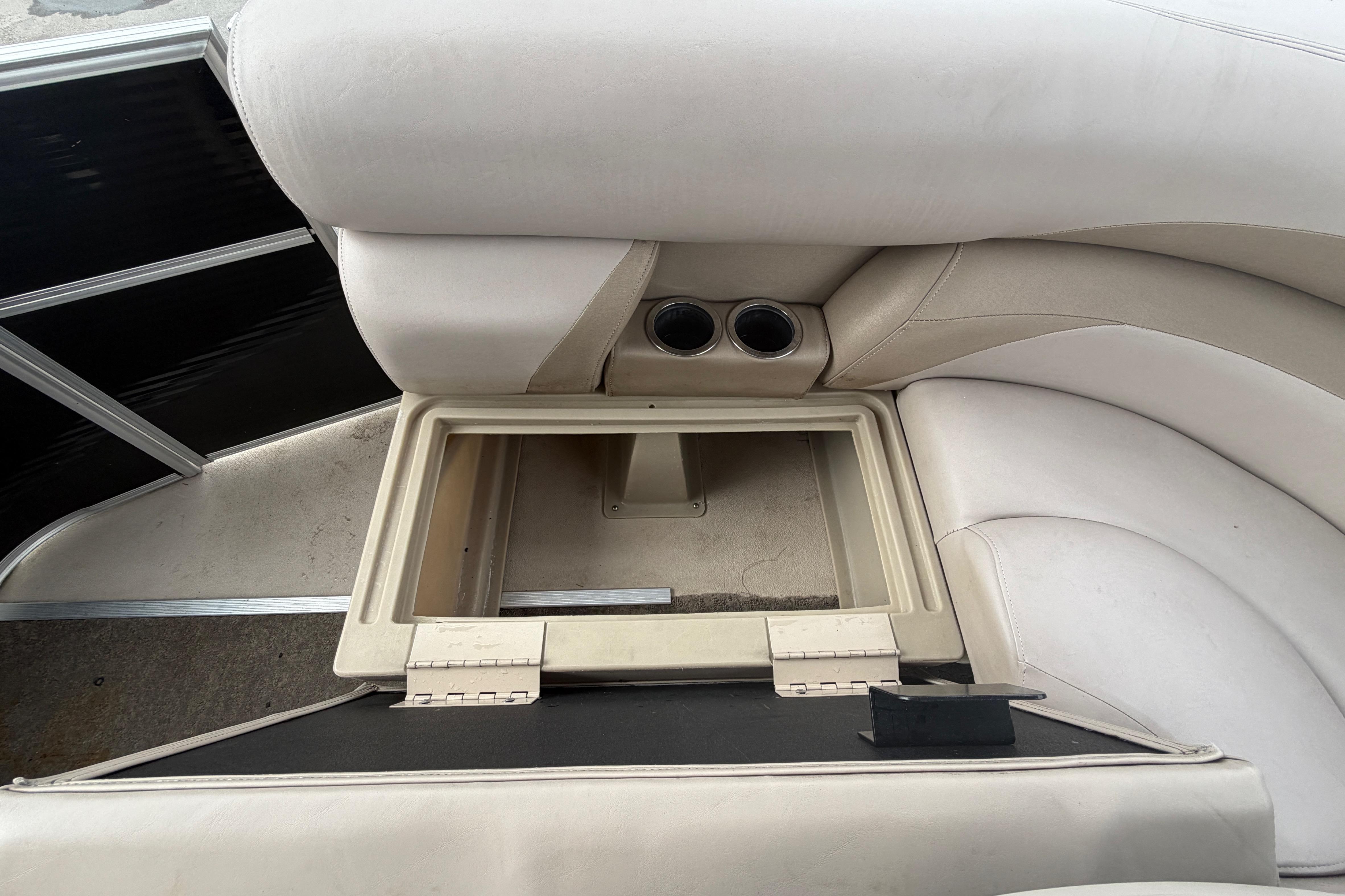 2014 Starcraft Stardeck 190 Cruise boat interior with open storage compartment and cup holders.