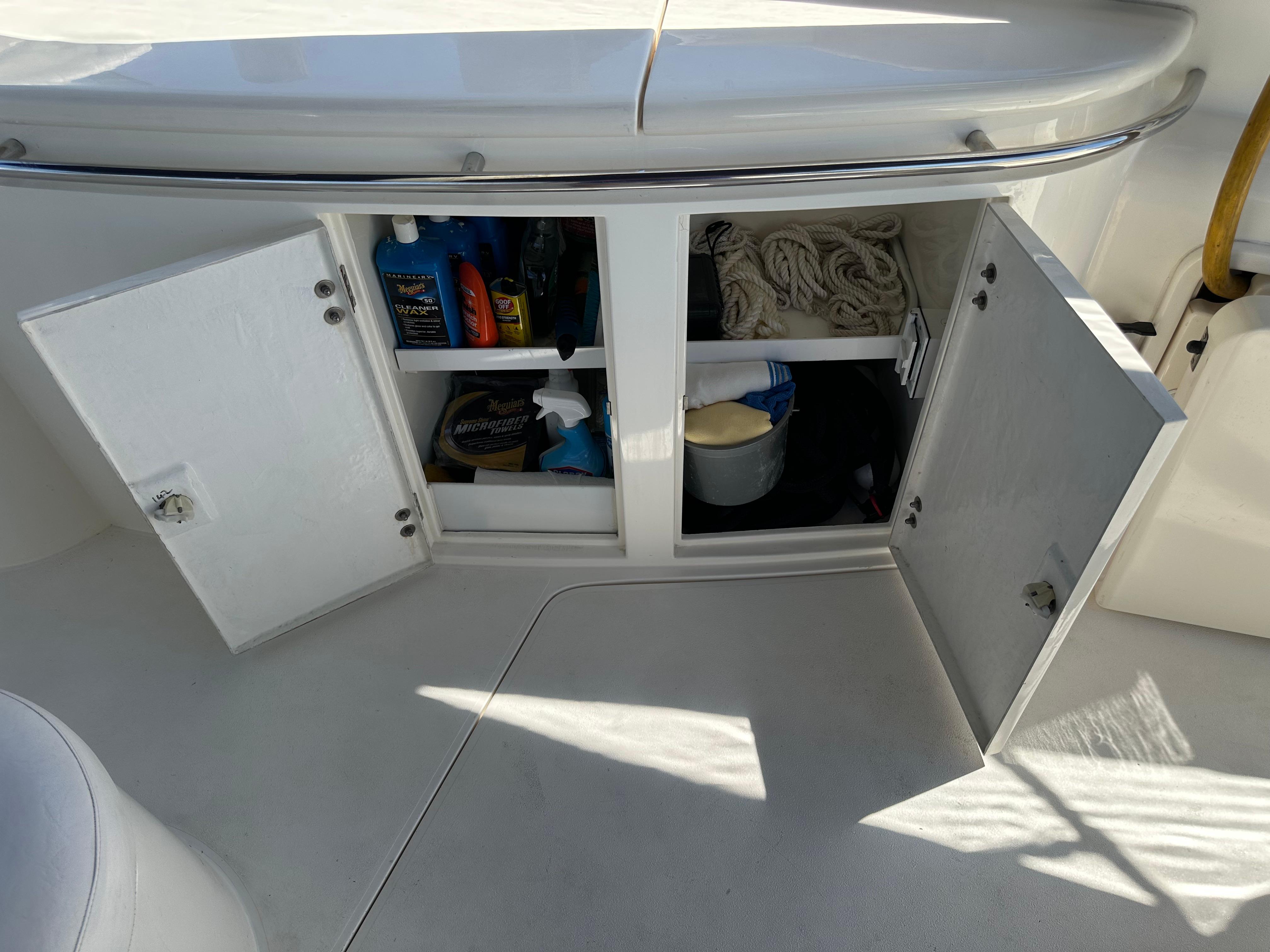 Open storage cabinet on 1997 Sunseeker Camargue 47 yacht, containing cleaning supplies and ropes.