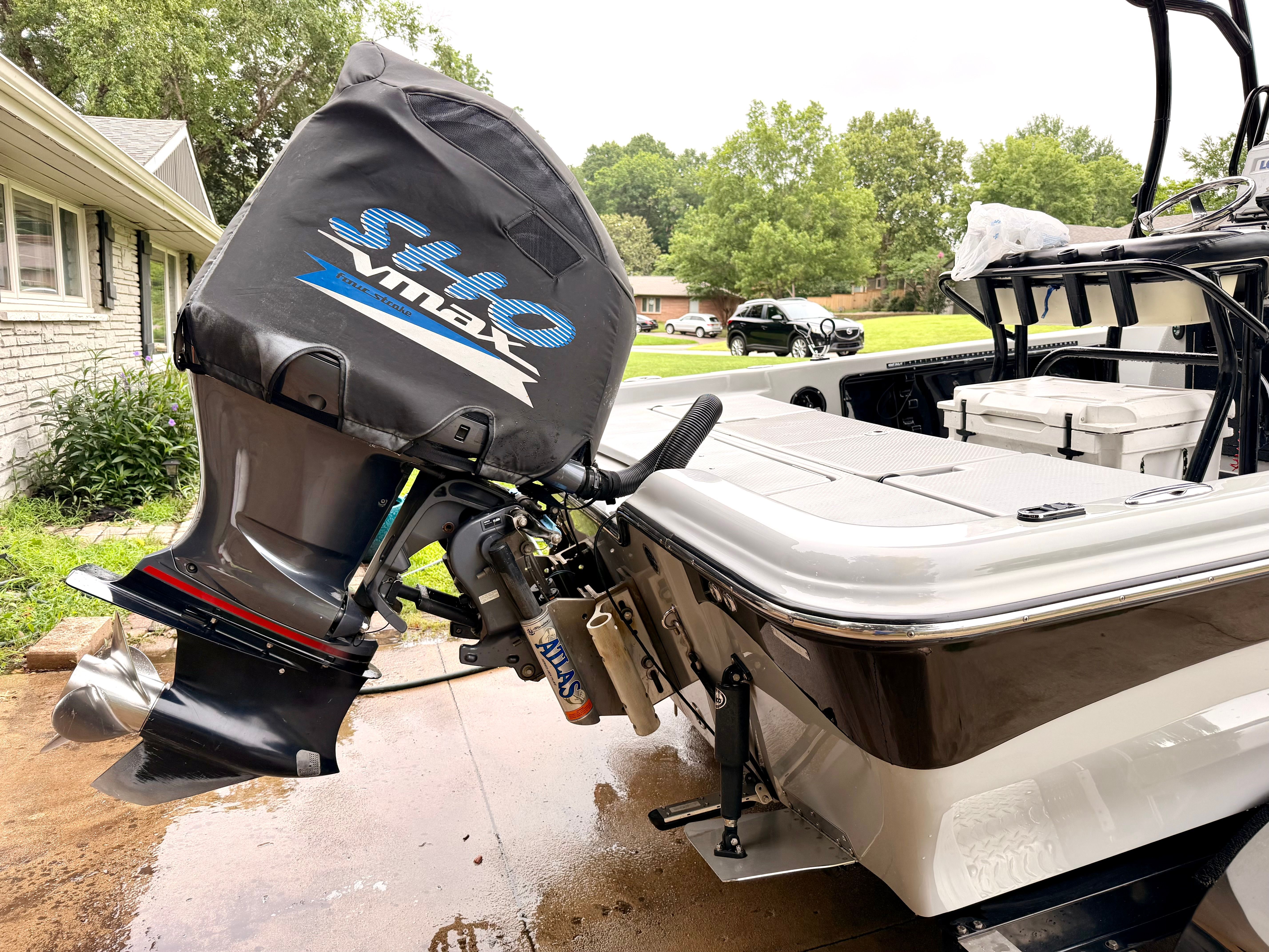 A 2013 Blue Wave Pure Bay 2200 with a Yamaha outboard motor, parked in a driveway.