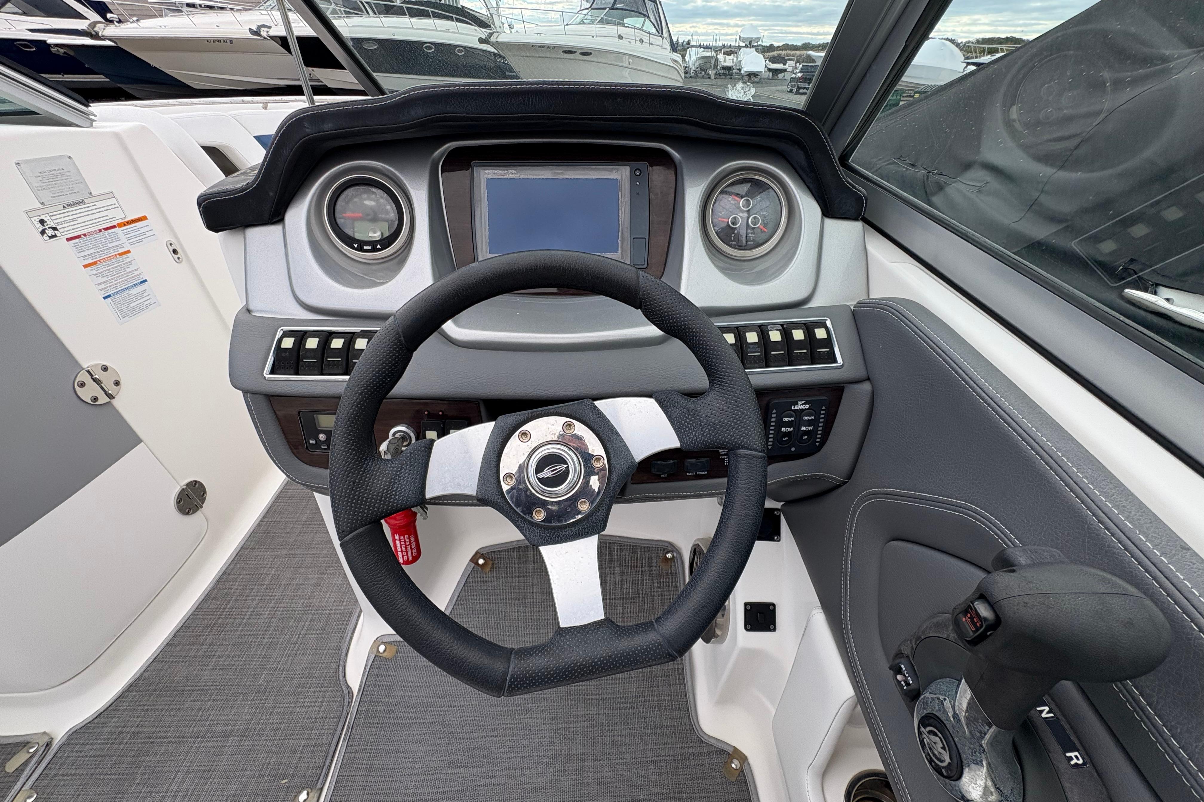 2015 Chaparral 264 Sunesta boat dashboard with steering wheel and control panel.
