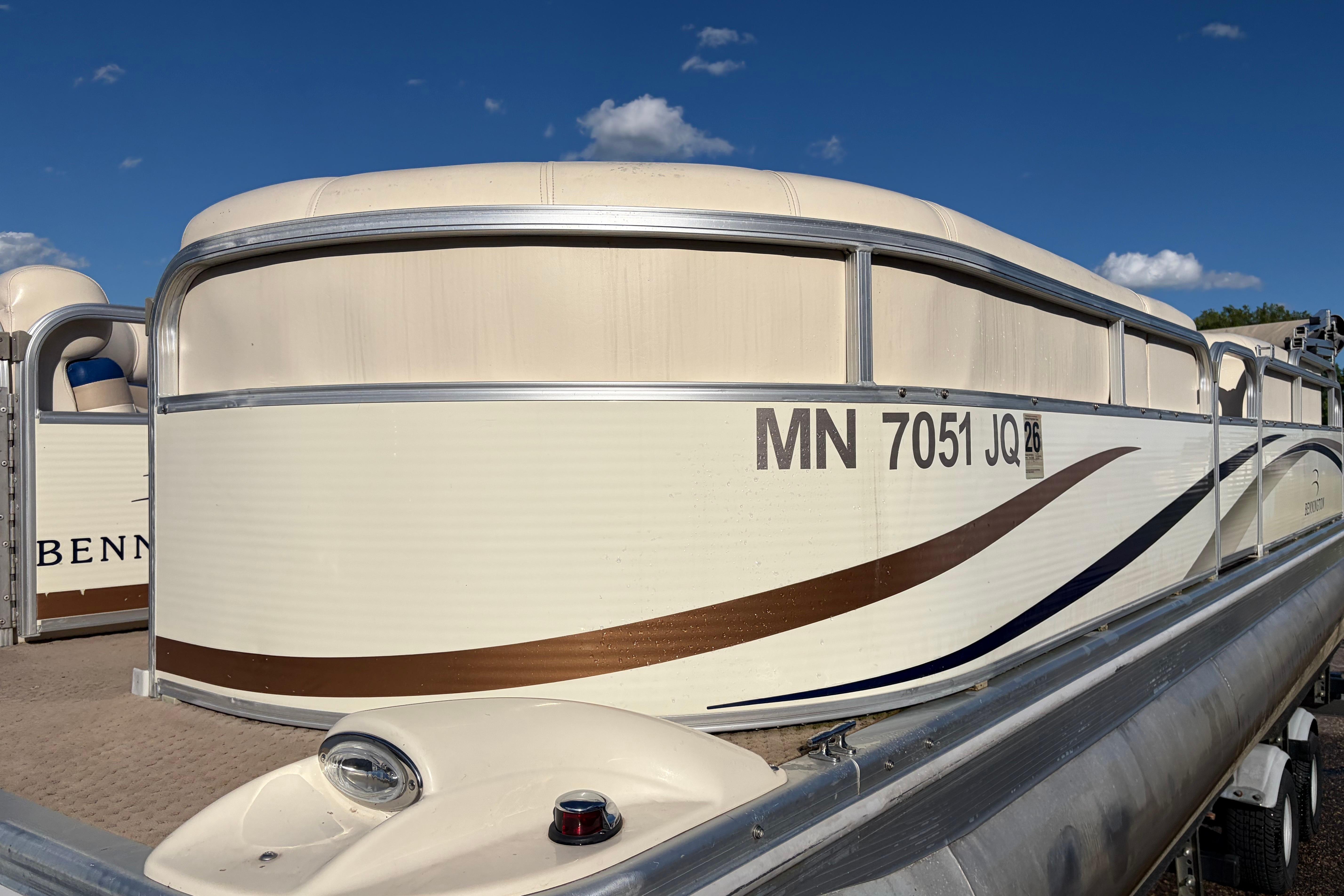 2003 Bennington 2250RSi pontoon boat docked under a clear blue sky.