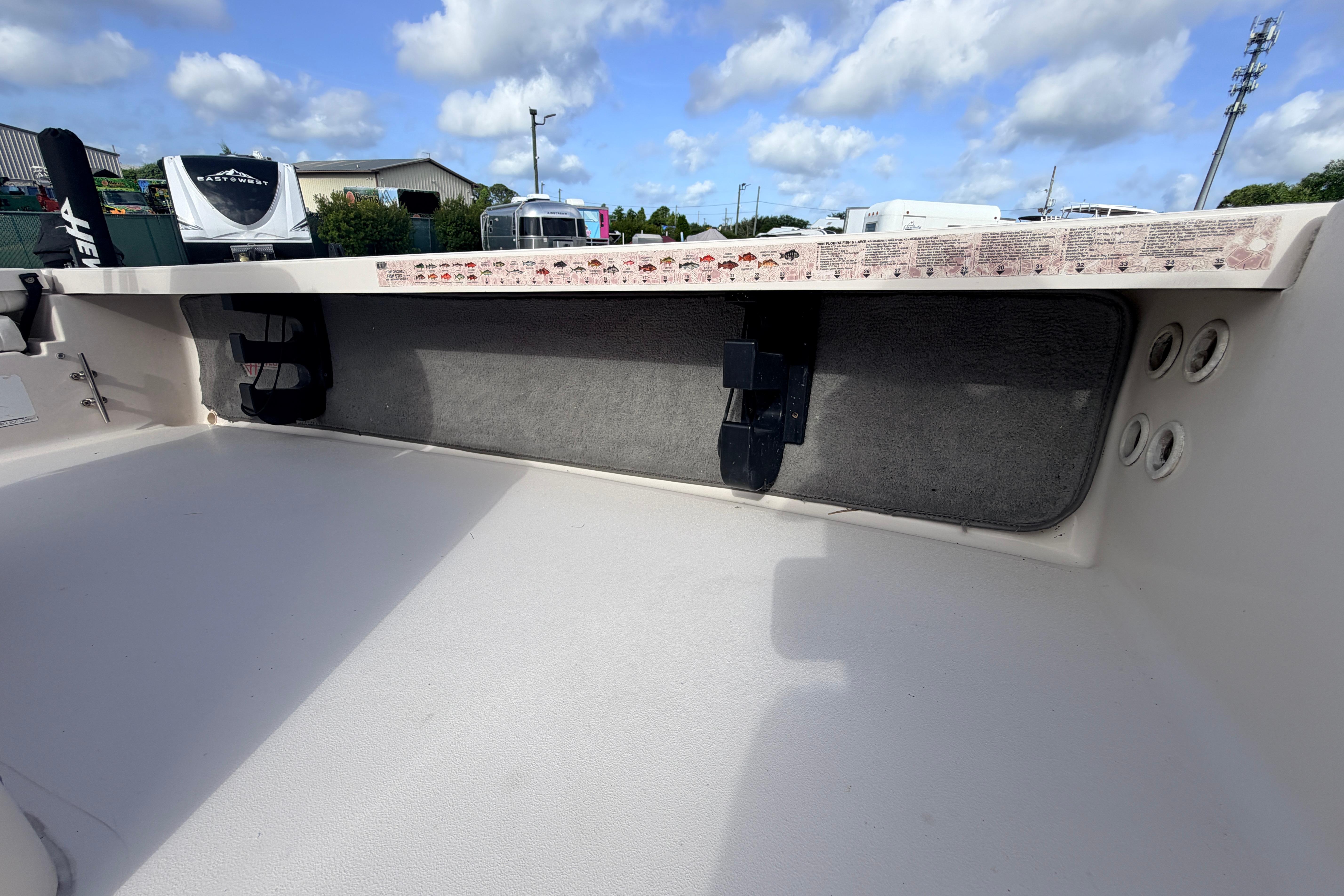 2004 Hewes Redfisher 18 boat interior with storage compartment and rod holders.