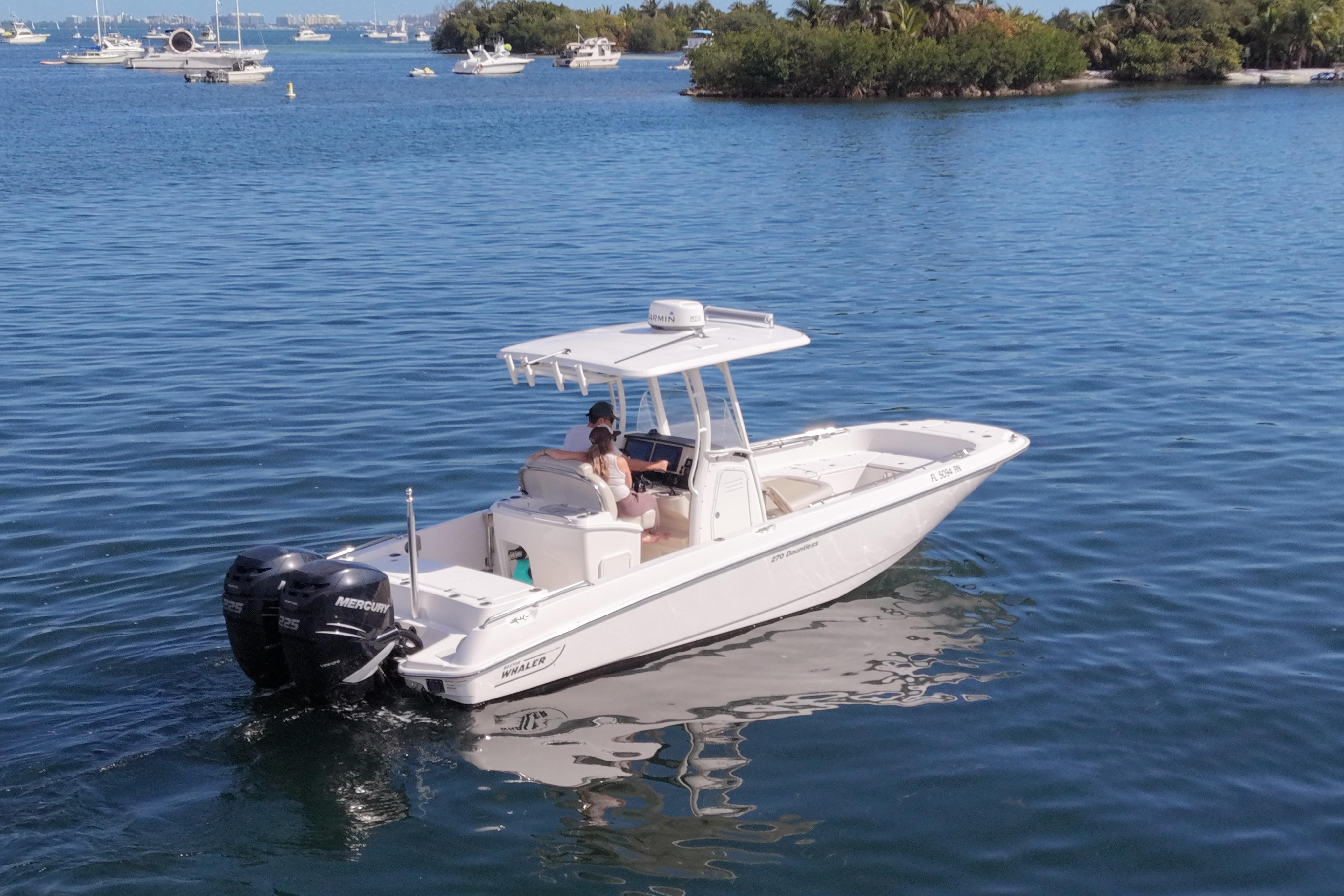 2018 Boston Whaler 270 Dauntless boat cruising on a serene lake.