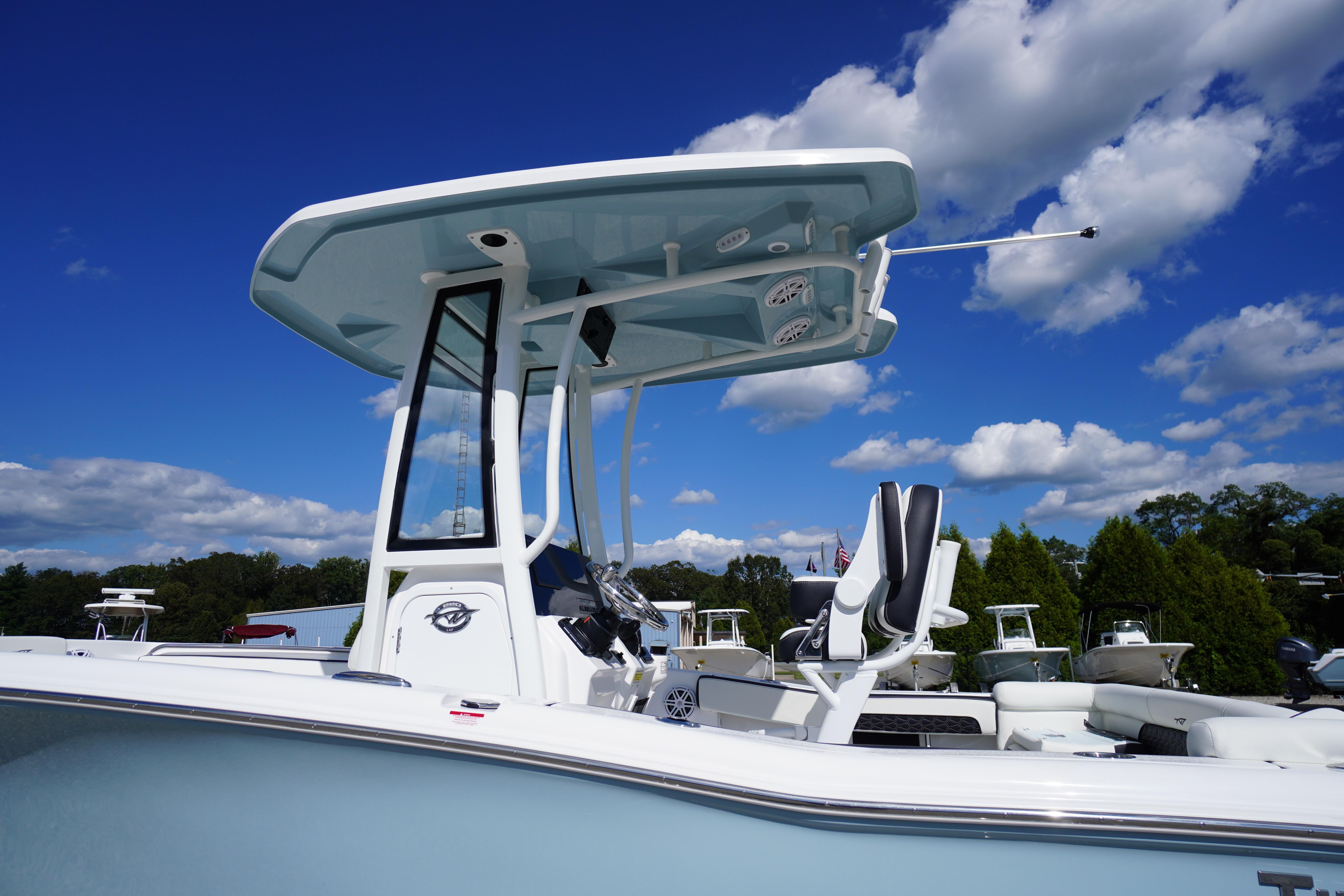 2026 Tidewater 220 LXF boat with T-top against a clear blue sky.