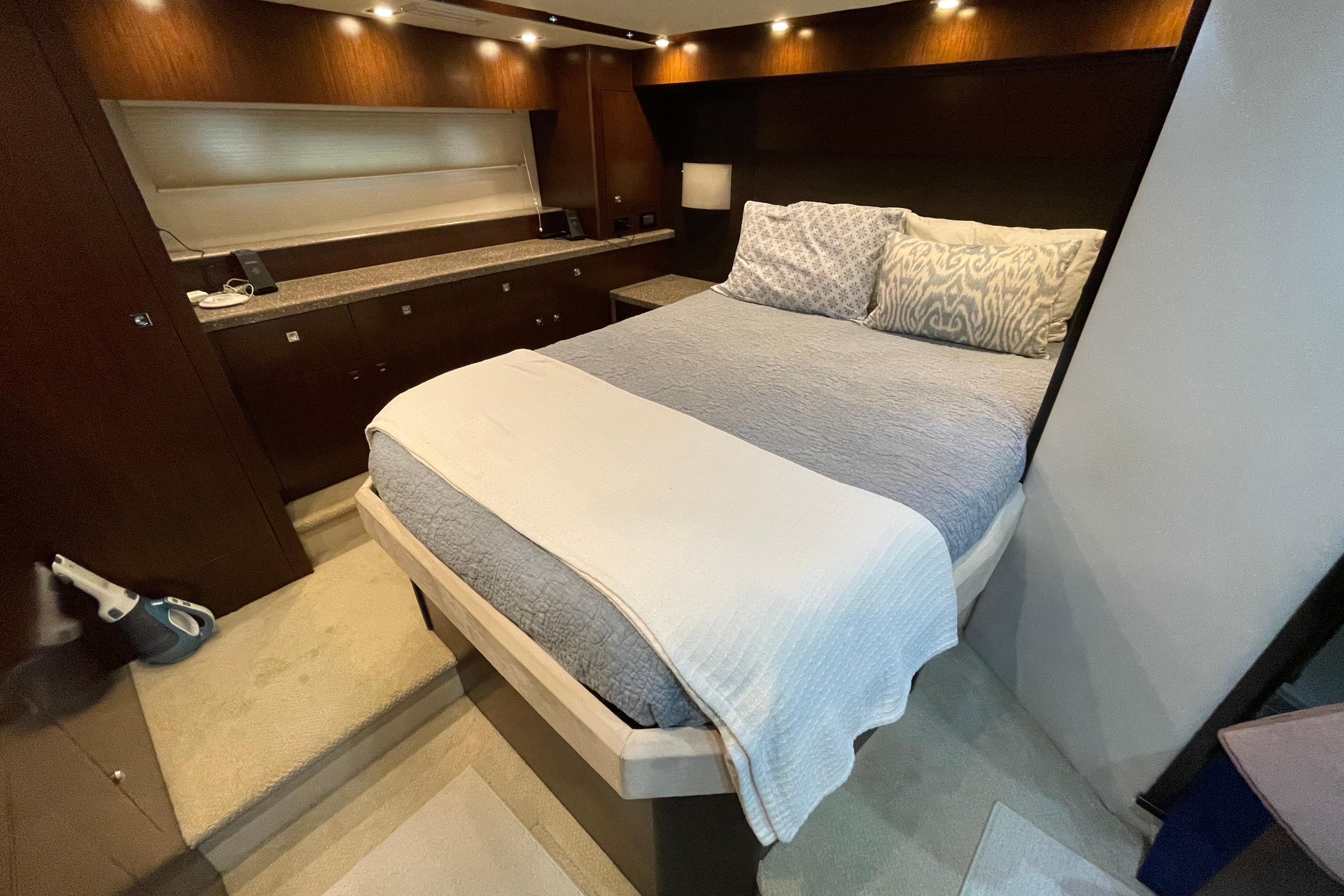 Luxurious bedroom interior of 2012 Cruisers Yachts 48 Cantius with elegant bedding and ambient lighting.