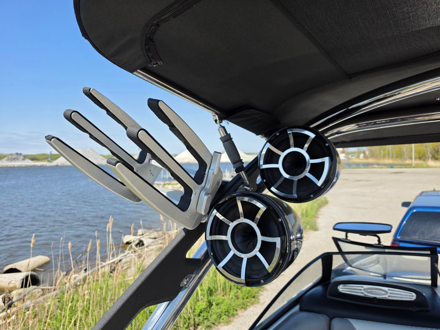 2014 Malibu Wakesetter 24 MXZ with speakers and wakeboard rack by the lake.