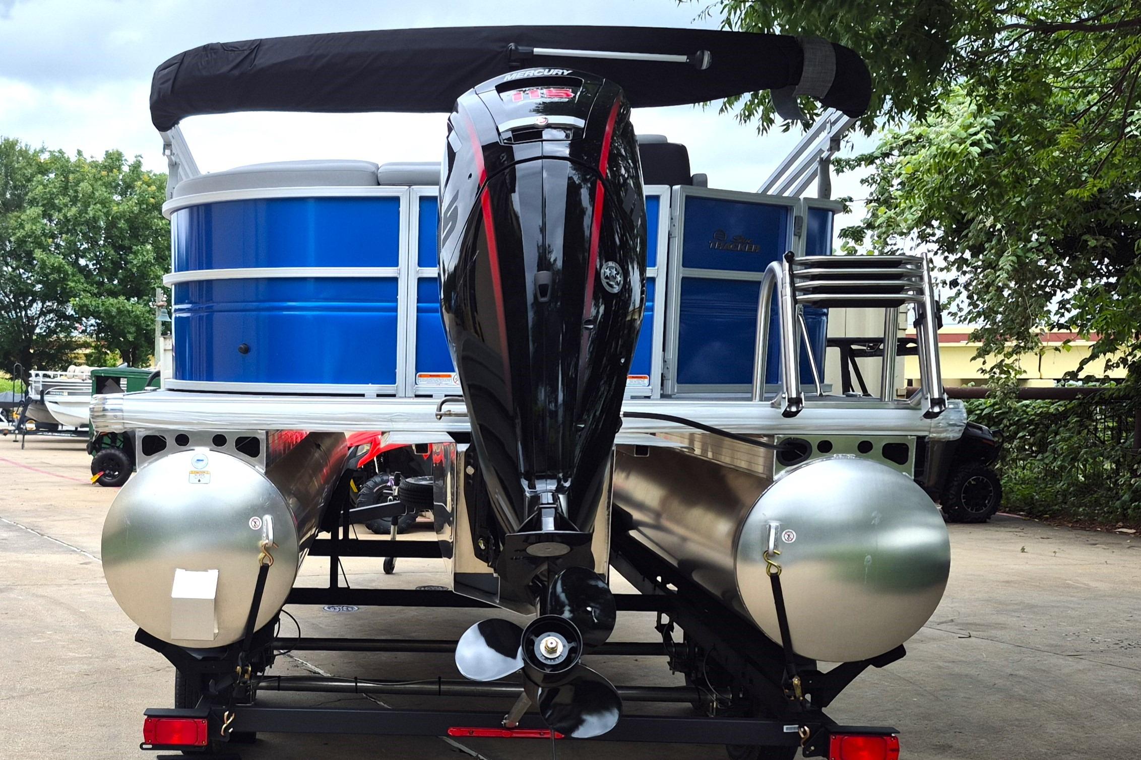 2026 Sun Tracker Party Barge 20 DLX pontoon boat with outboard motor, parked outdoors.