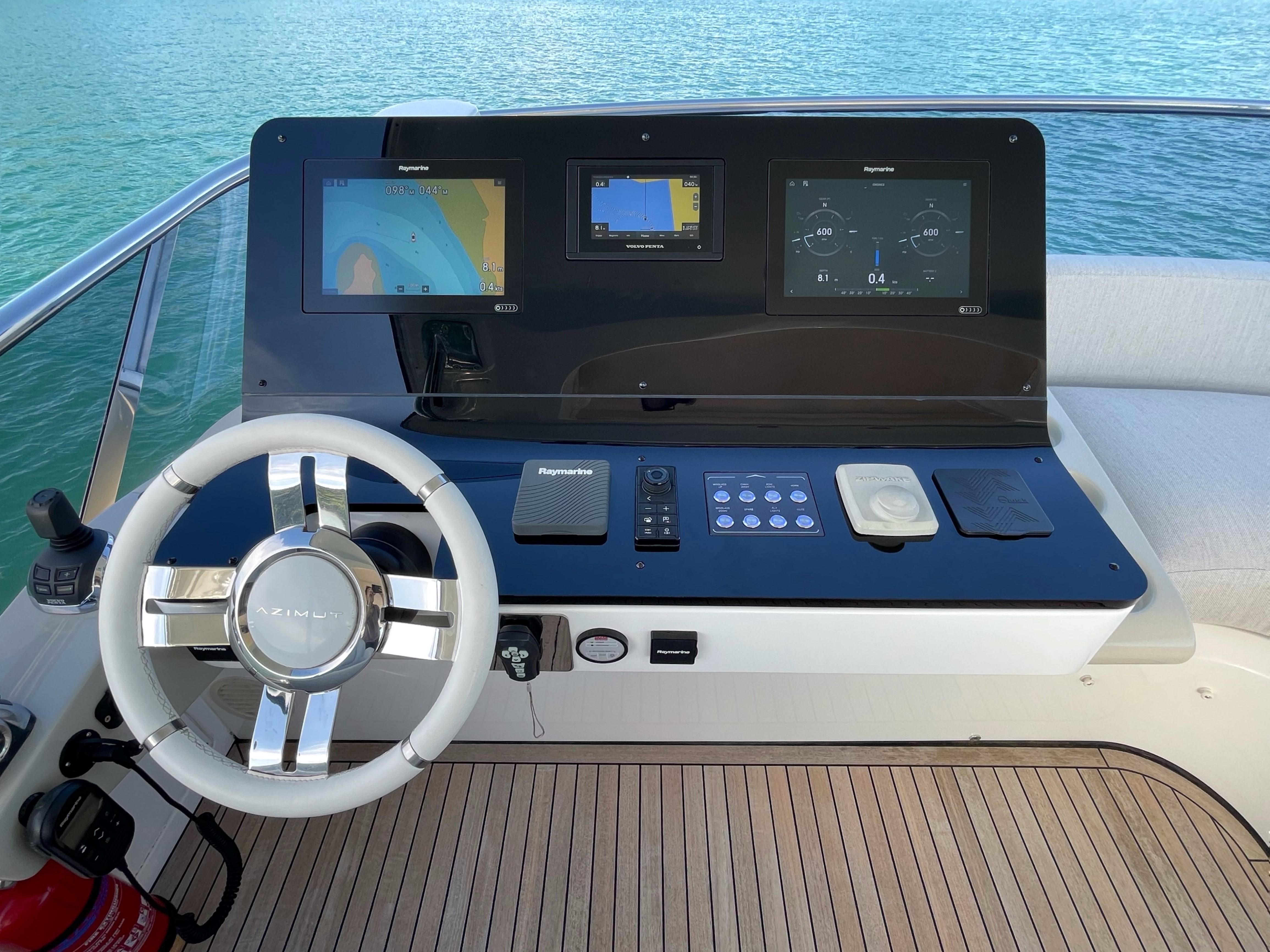 Helm of 2020 Azimut 60 yacht with navigation screens and steering wheel.