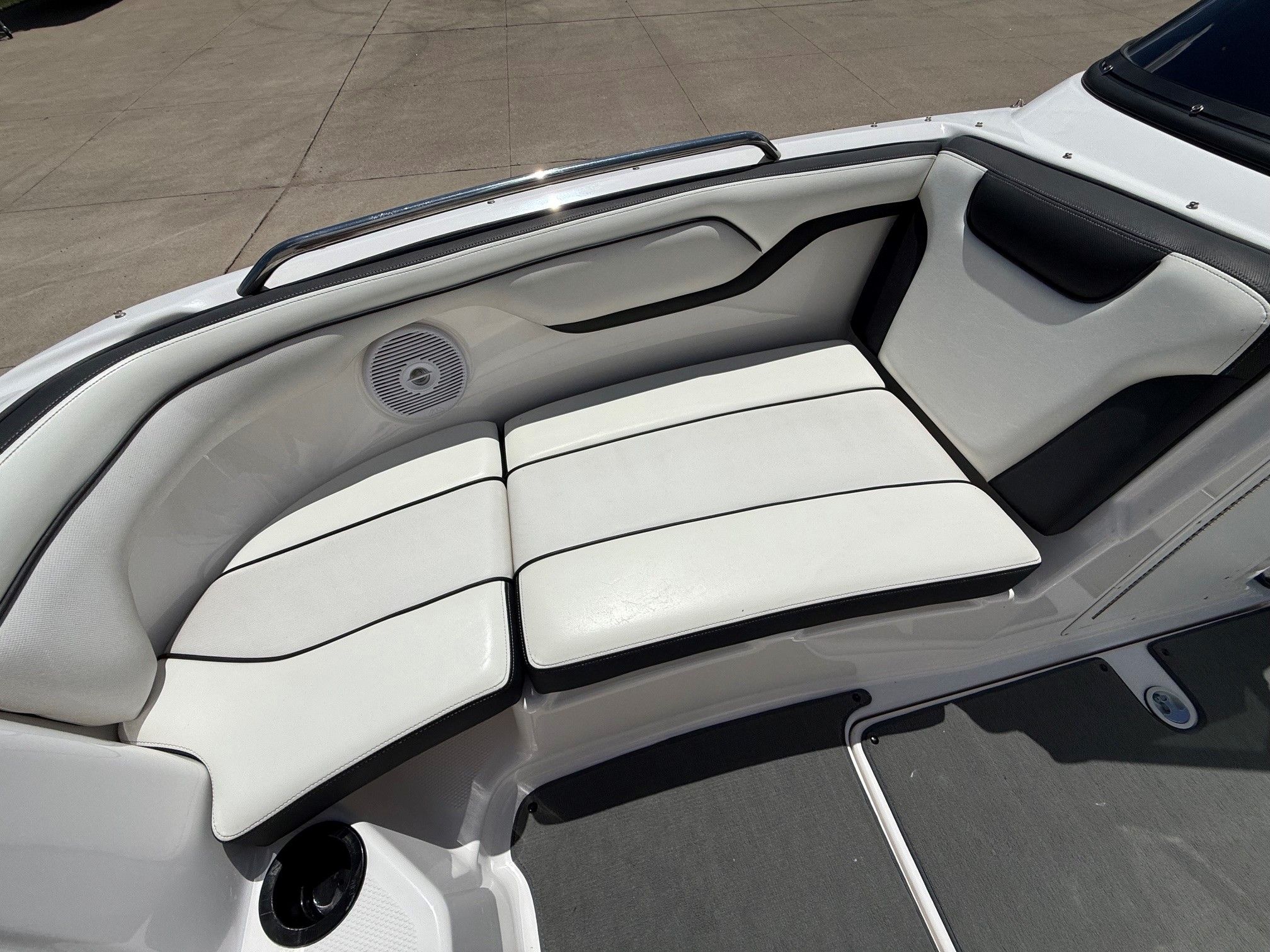 The bow seating area of a Yamaha SX210 boat with white cushions.