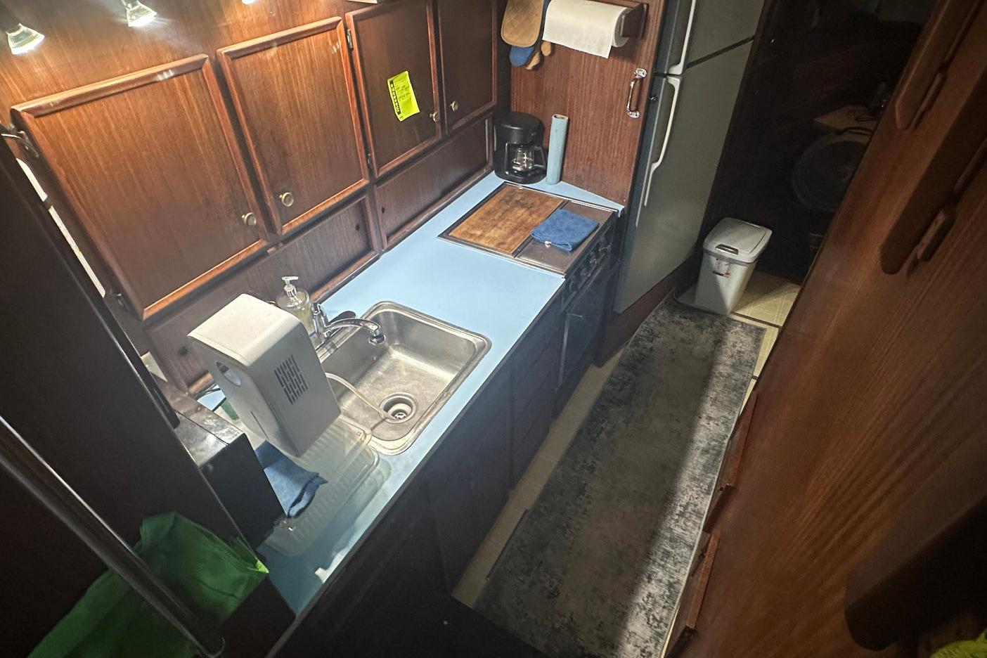 1981 Hatteras 43 Convertible yacht kitchen with wooden cabinets and modern appliances.