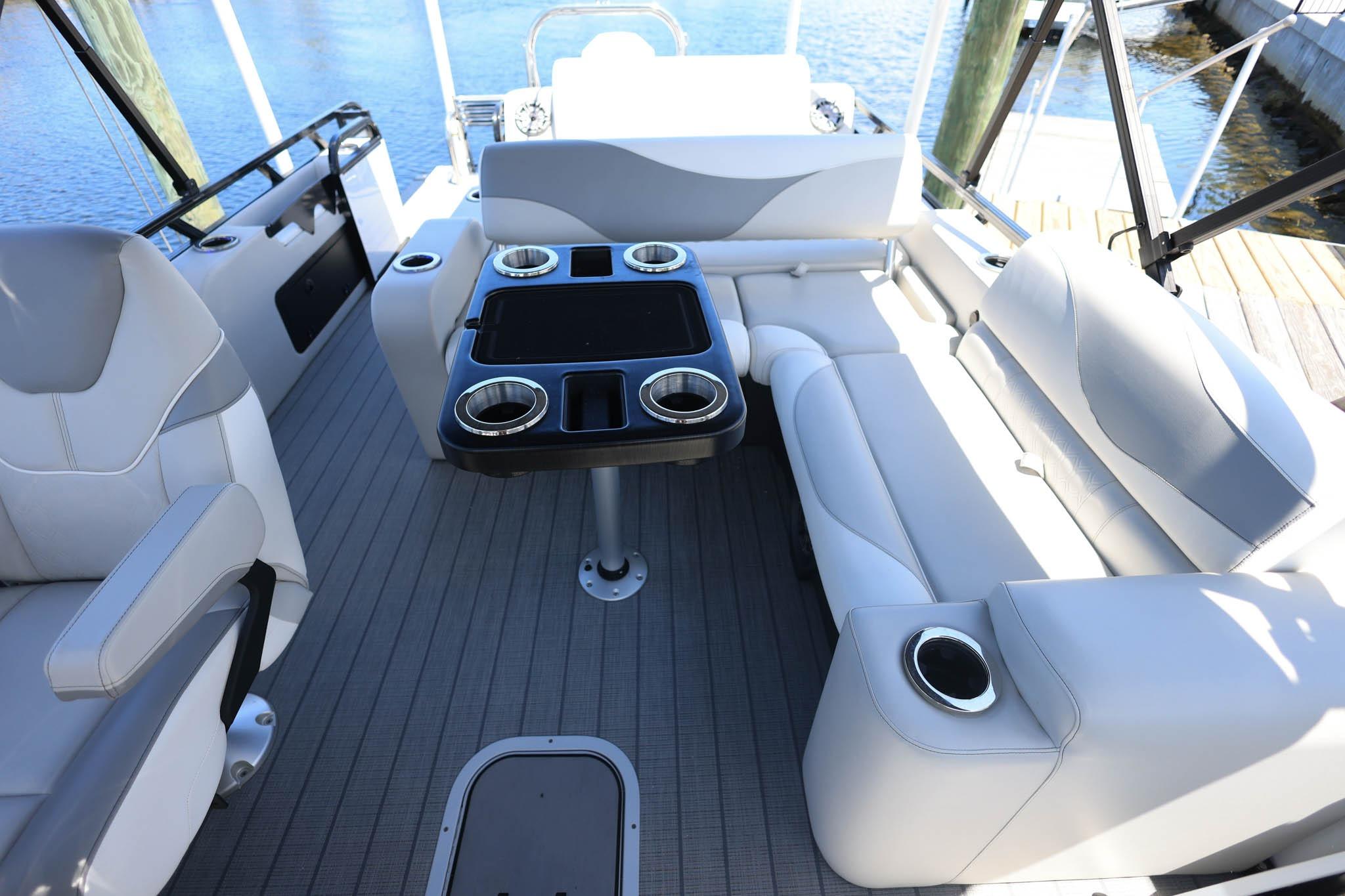 2025 Tahoe Pontoon LTZ 23 interior with sleek seating and table, docked by the water.