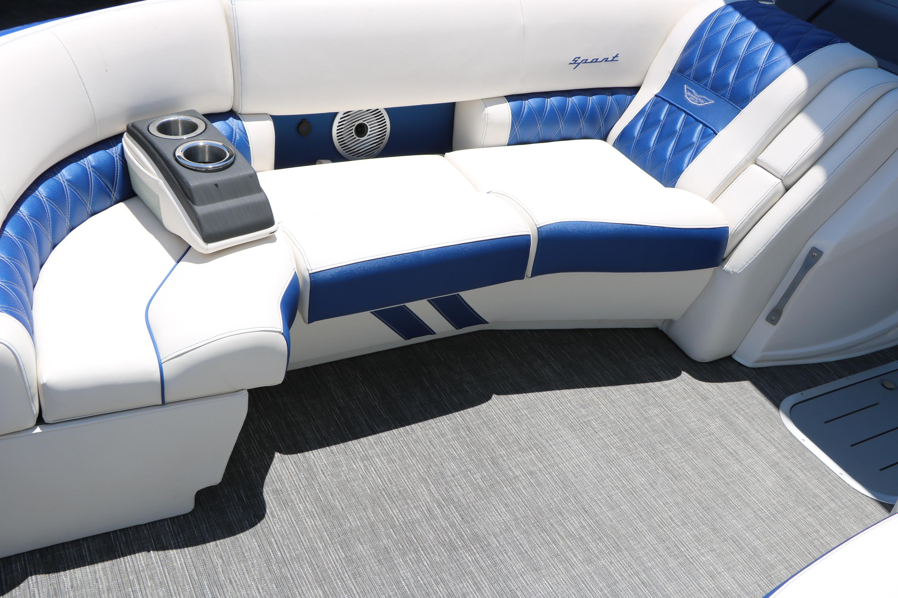 2024 Bennington 23 RX Swingback boat interior with blue and white seating and cup holders.