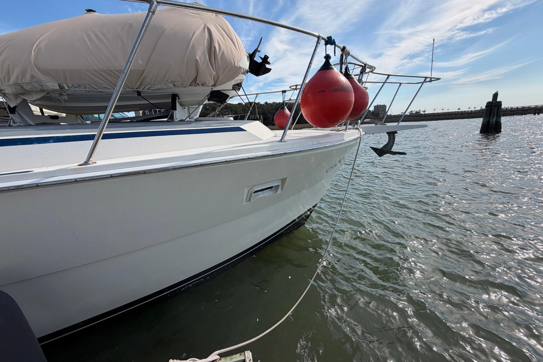 1987 Viking 44 Motor Yacht with red buoys docked on calm water.