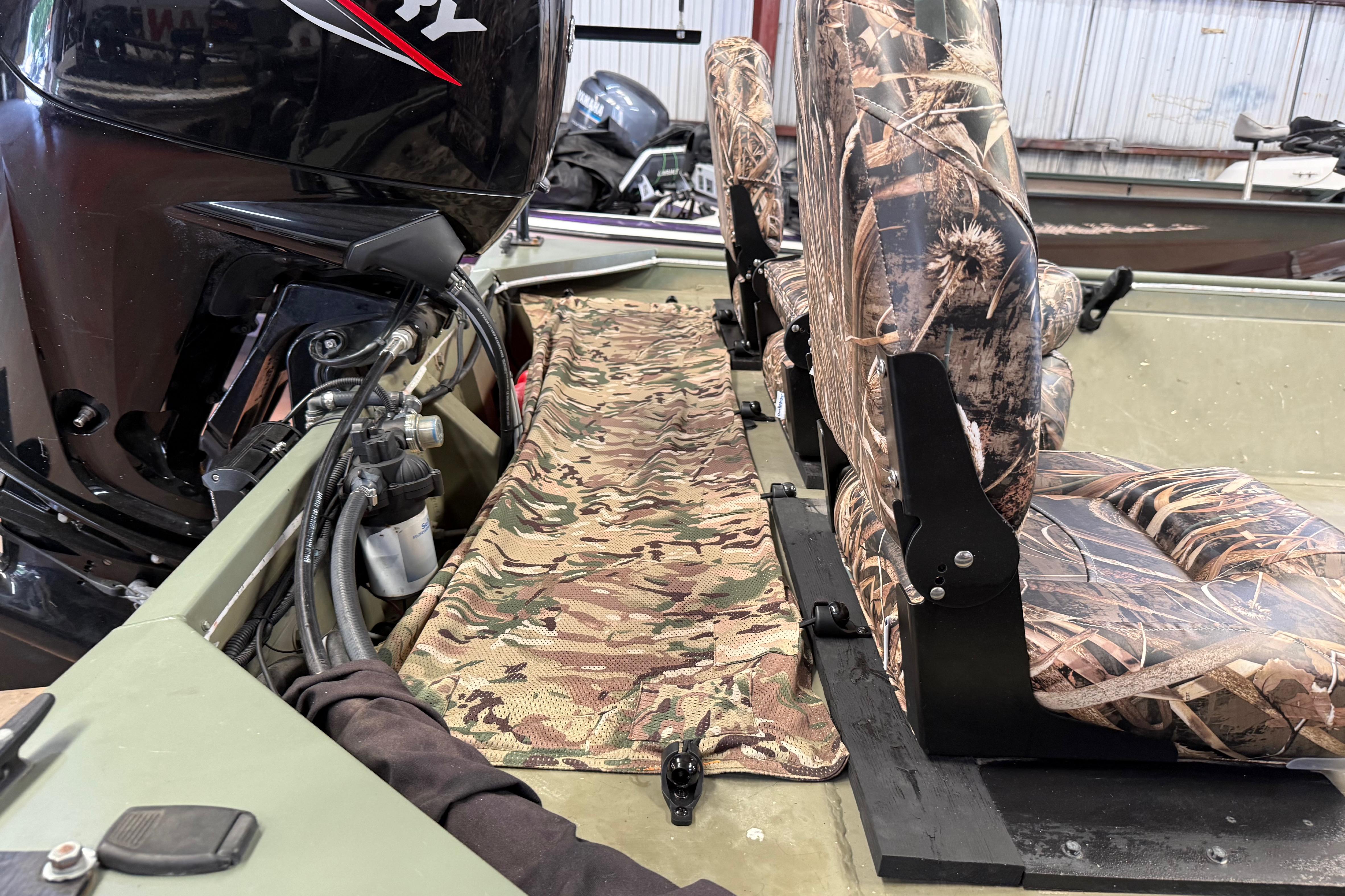 2020 Lowe Roughneck 2070 Big River boat interior with camouflage seats and powerful outboard motor.