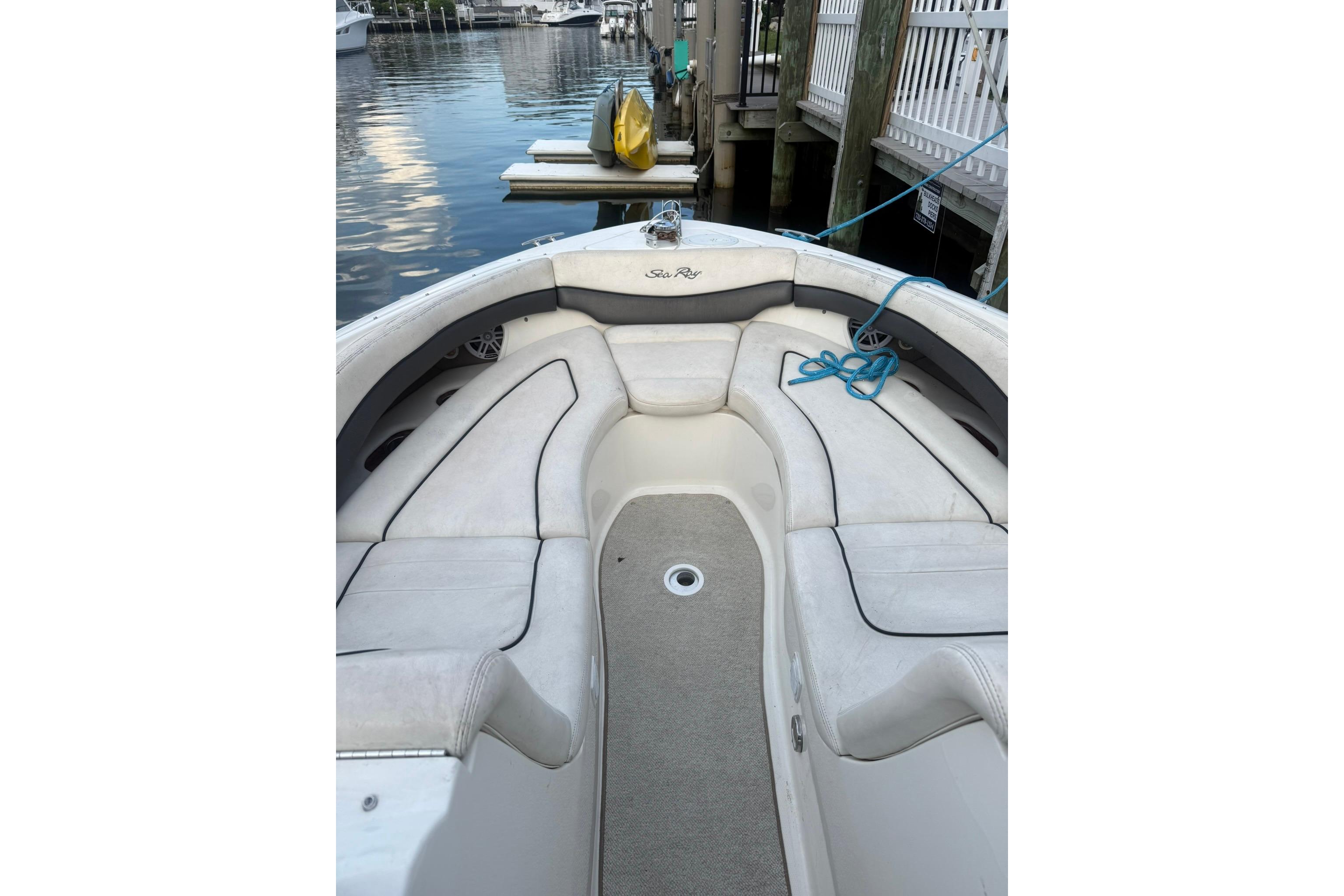 2005 Sea Ray 290 SLX boat interior with white seating and blue rope at dock.
