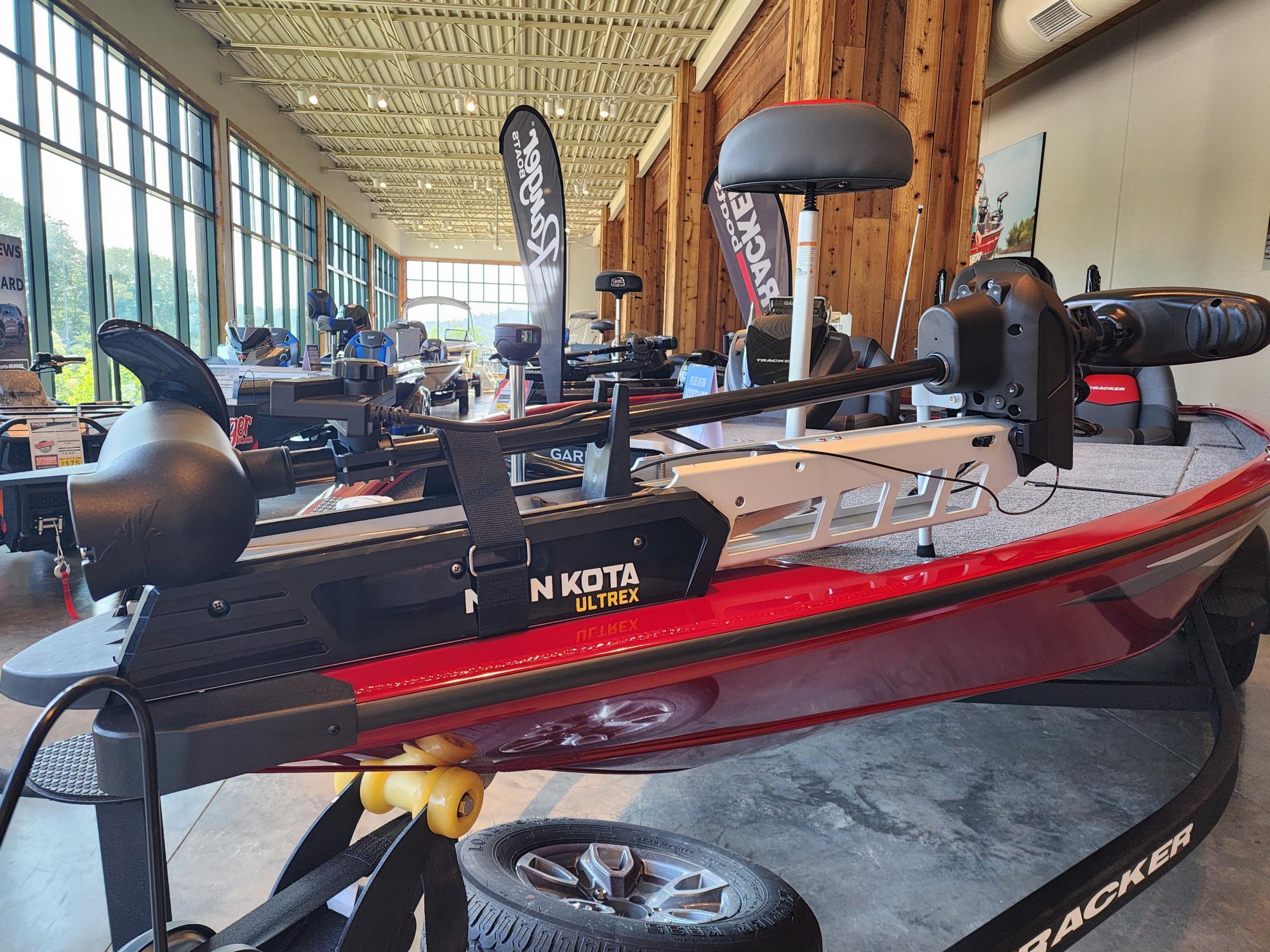 A red Tracker Savage 215 boat in a showroom.