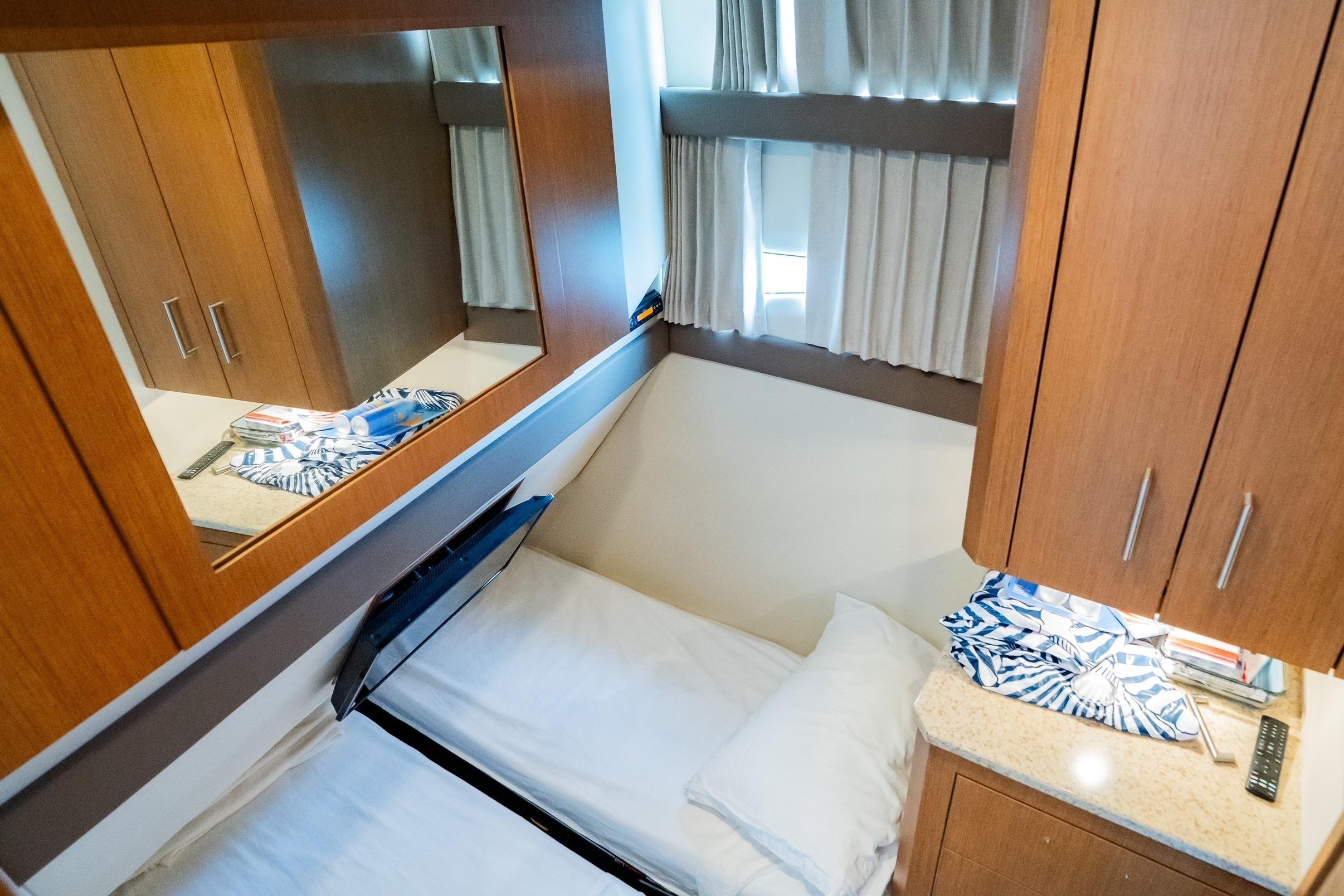 Cozy cabin interior of 2011 Carver 44 Sojourn yacht with bed and wooden cabinetry.