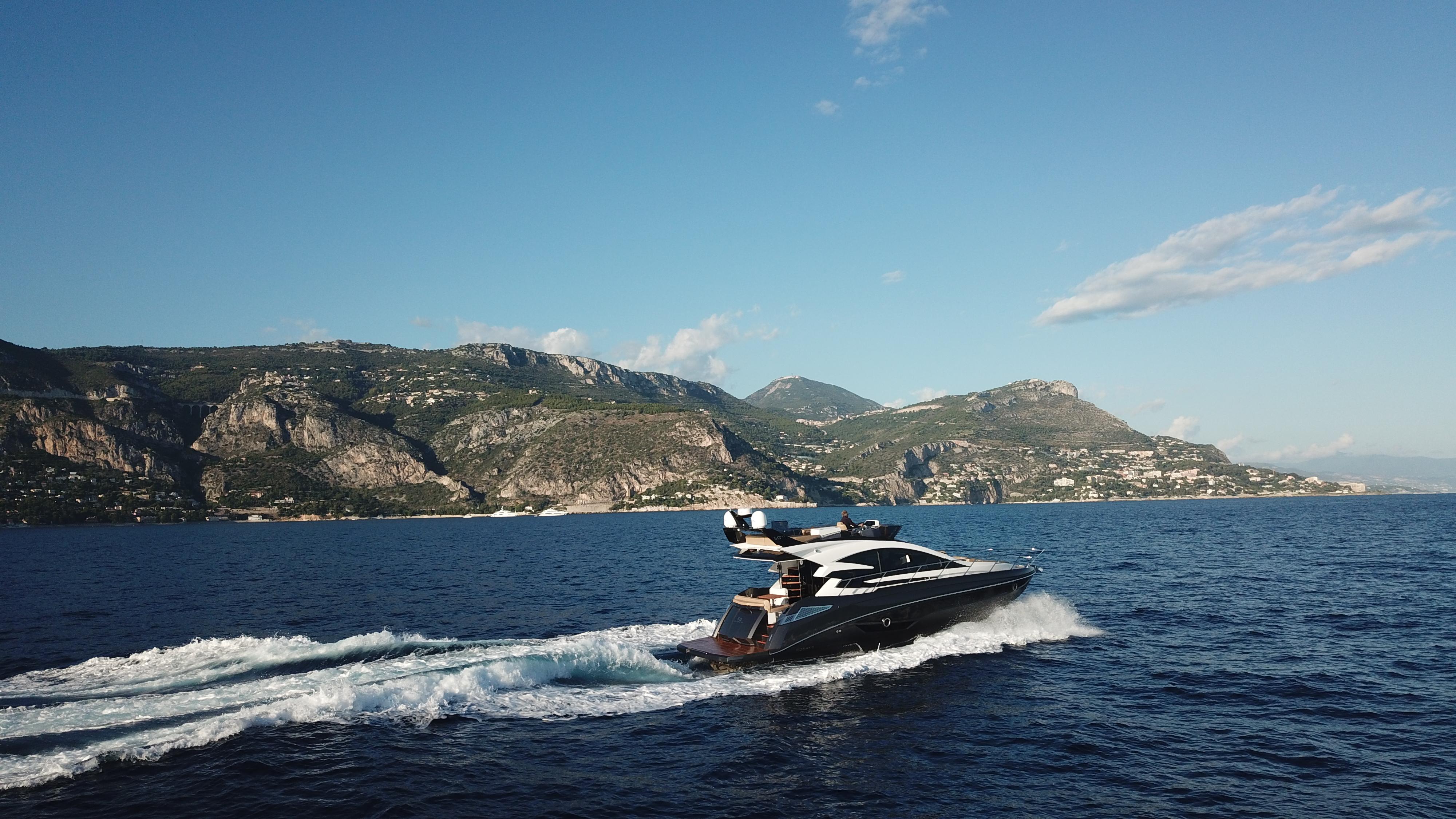 2025 Cobrey 52 FLY yacht cruising on scenic coastal waters.