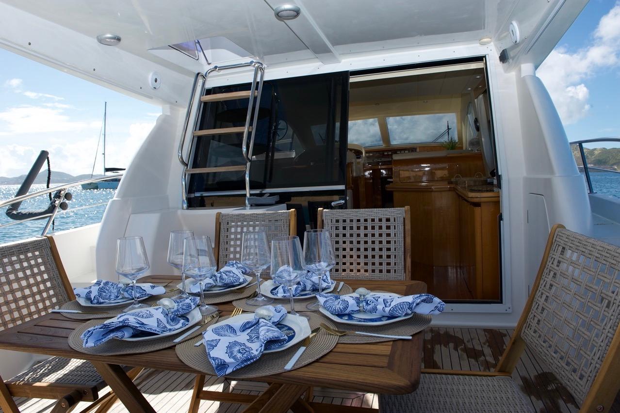 Elegant dining setup on a 2001 Raffaelli Maestrale 52 yacht, featuring ocean views.