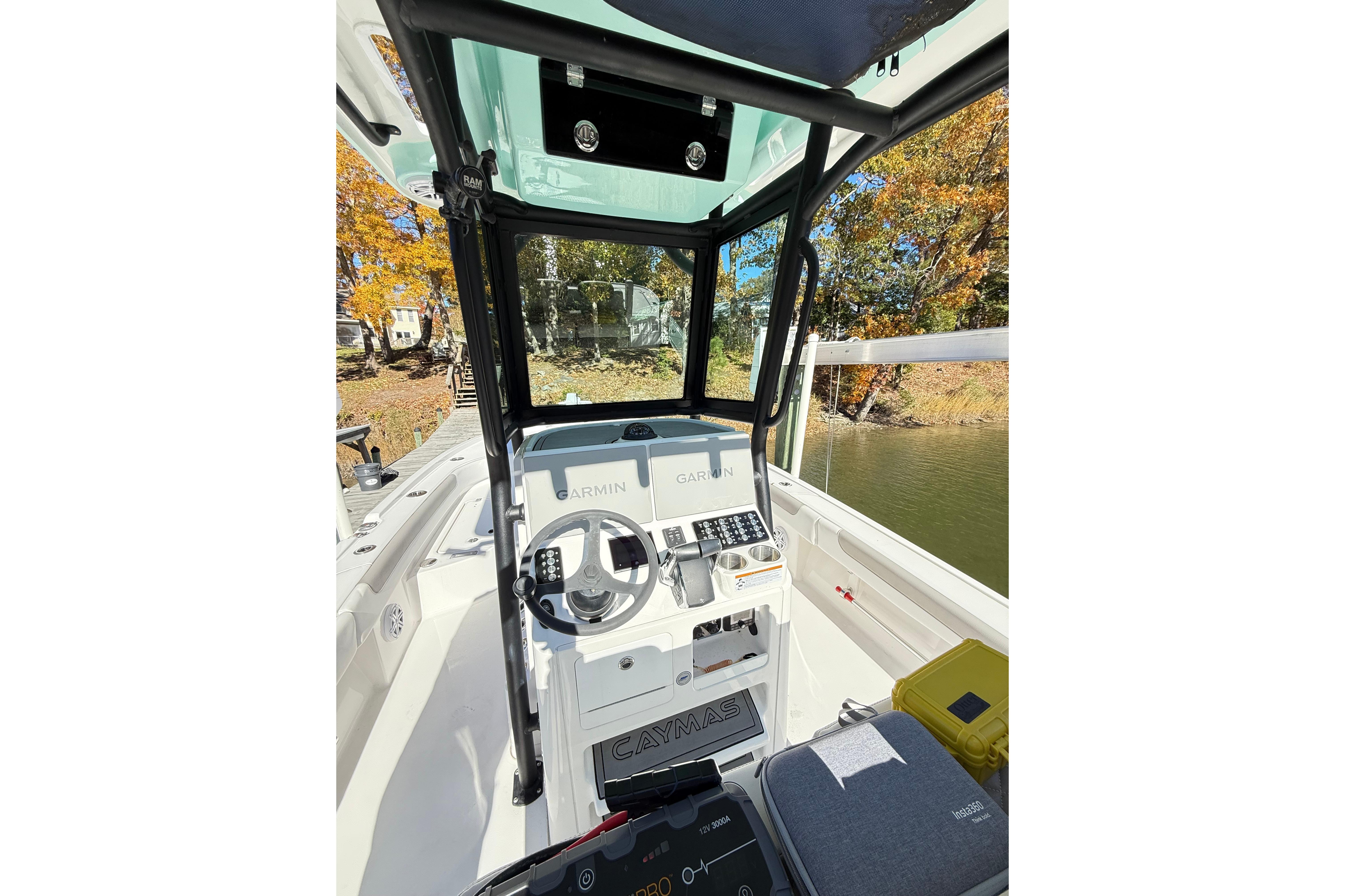 2023 Caymas 281 HB boat cockpit with Garmin navigation, surrounded by autumn foliage.