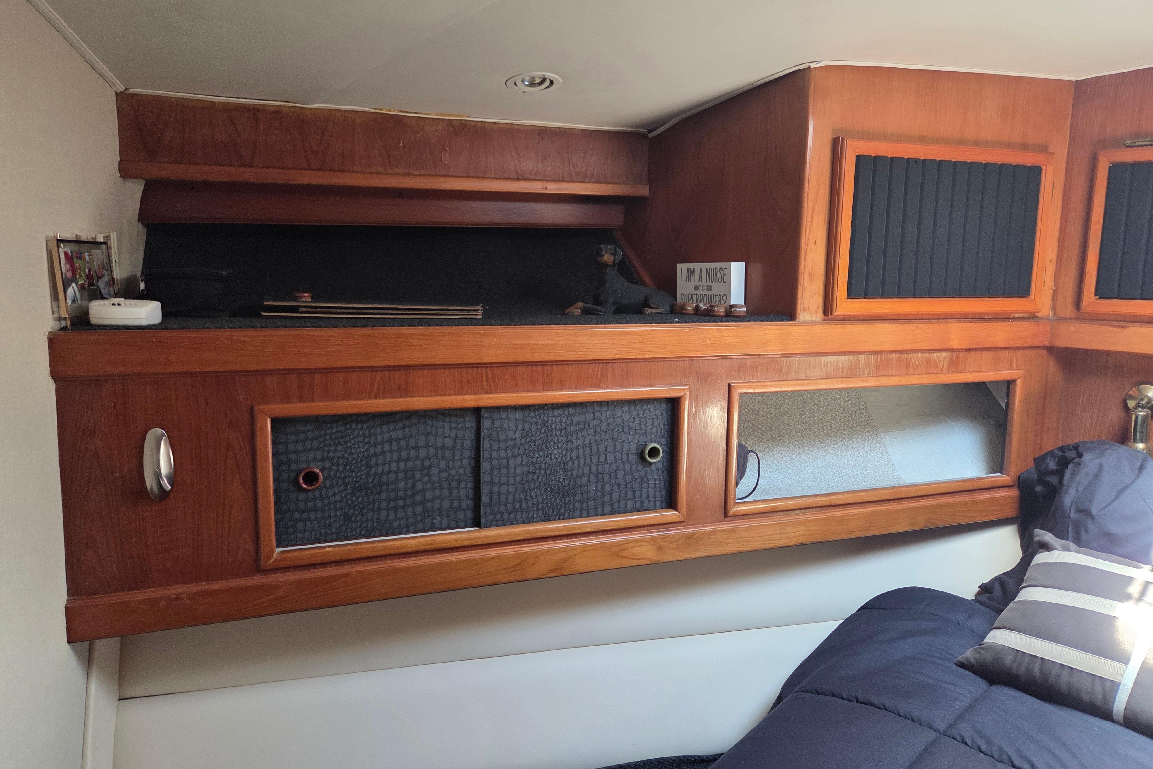 Interior of 1990 Egg Harbor Golden Egg 42 yacht with wooden cabinetry and cozy bedding.