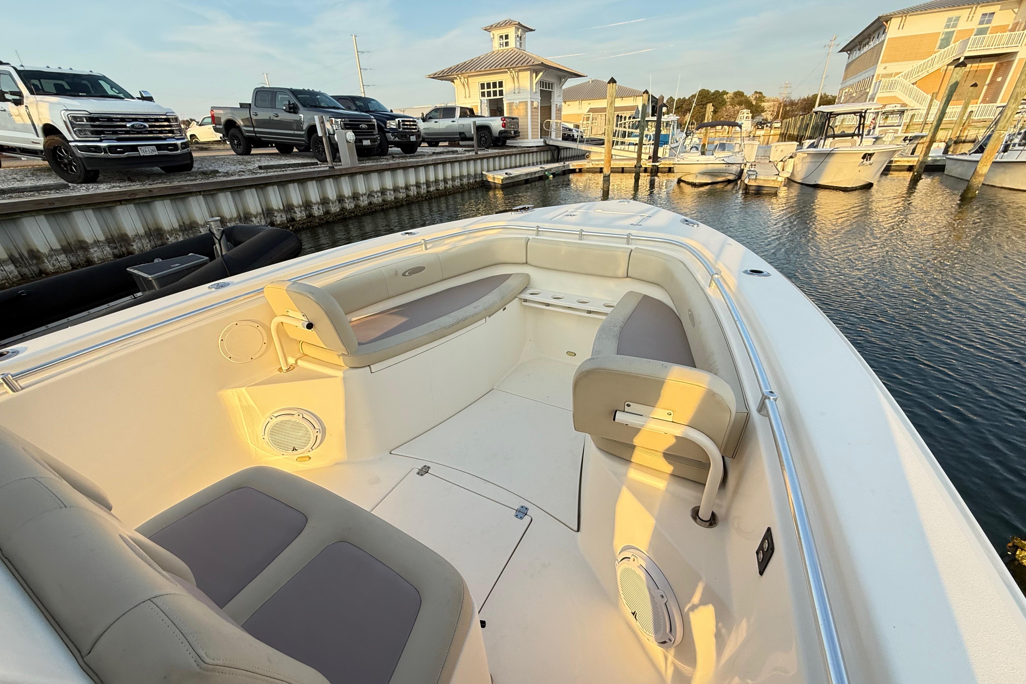 2016 Cobia 296 Center Console boat docked at marina with seating area.