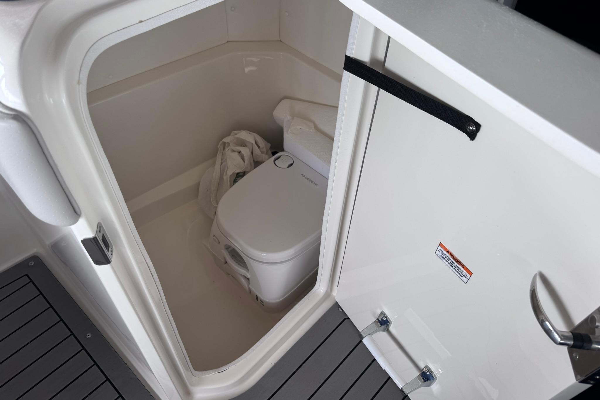 2021 Sea Ray SPX 230 boat interior with compact marine toilet.
