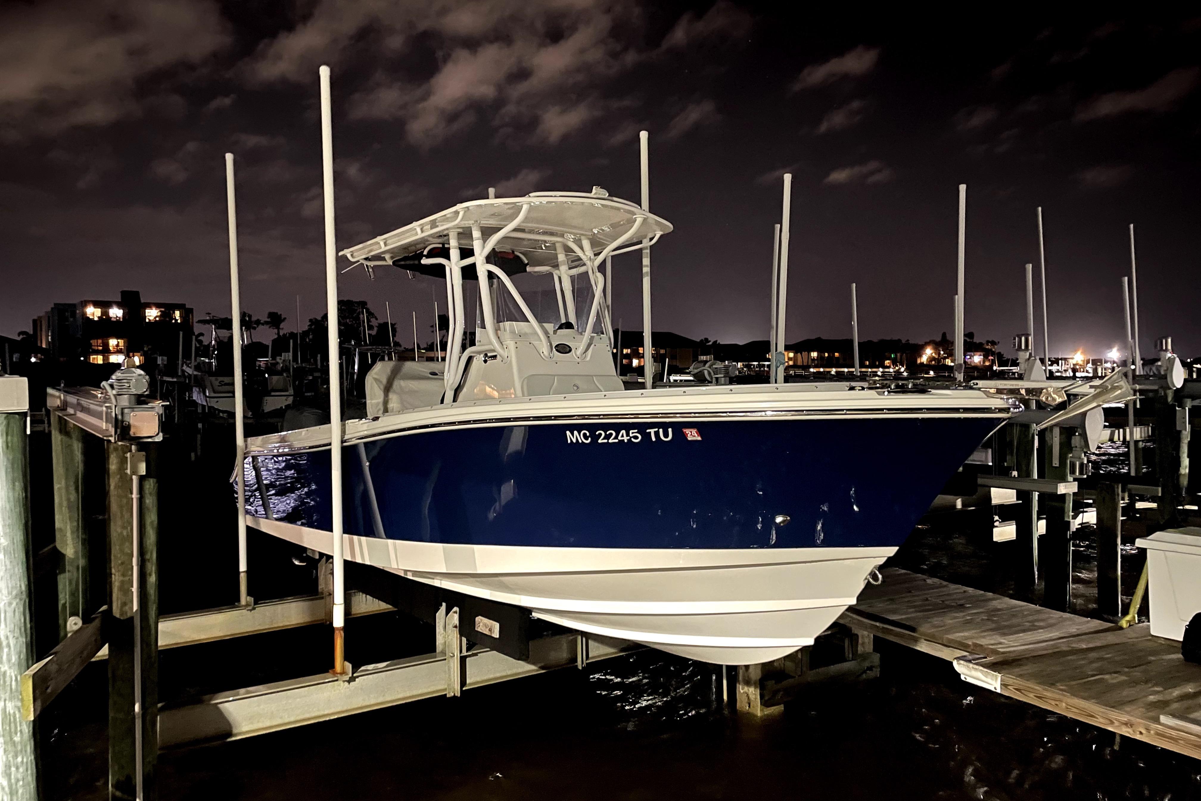 2015 Edgewater 245CC boat docked at night, illuminated by marina lights.