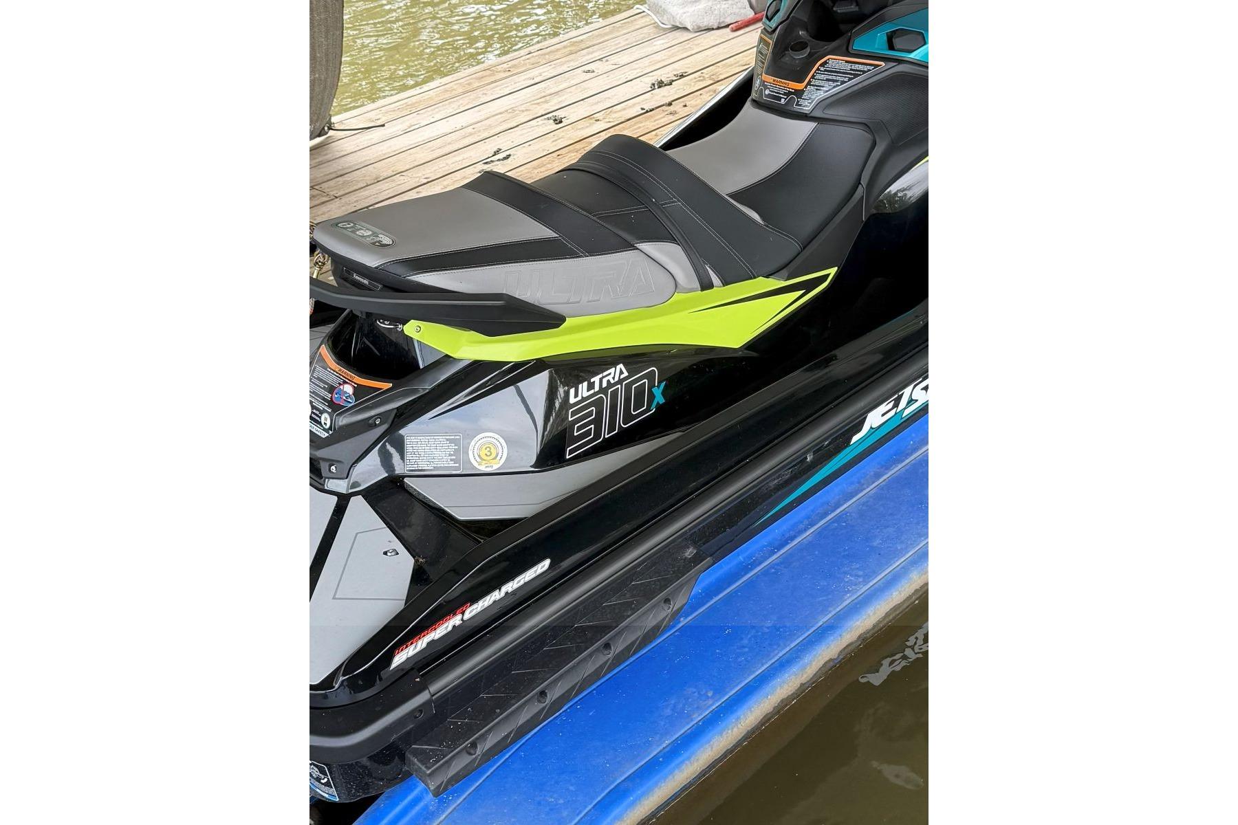 2023 Kawasaki Jetski Ultra 310X on dock, showcasing sleek design and vibrant colors.