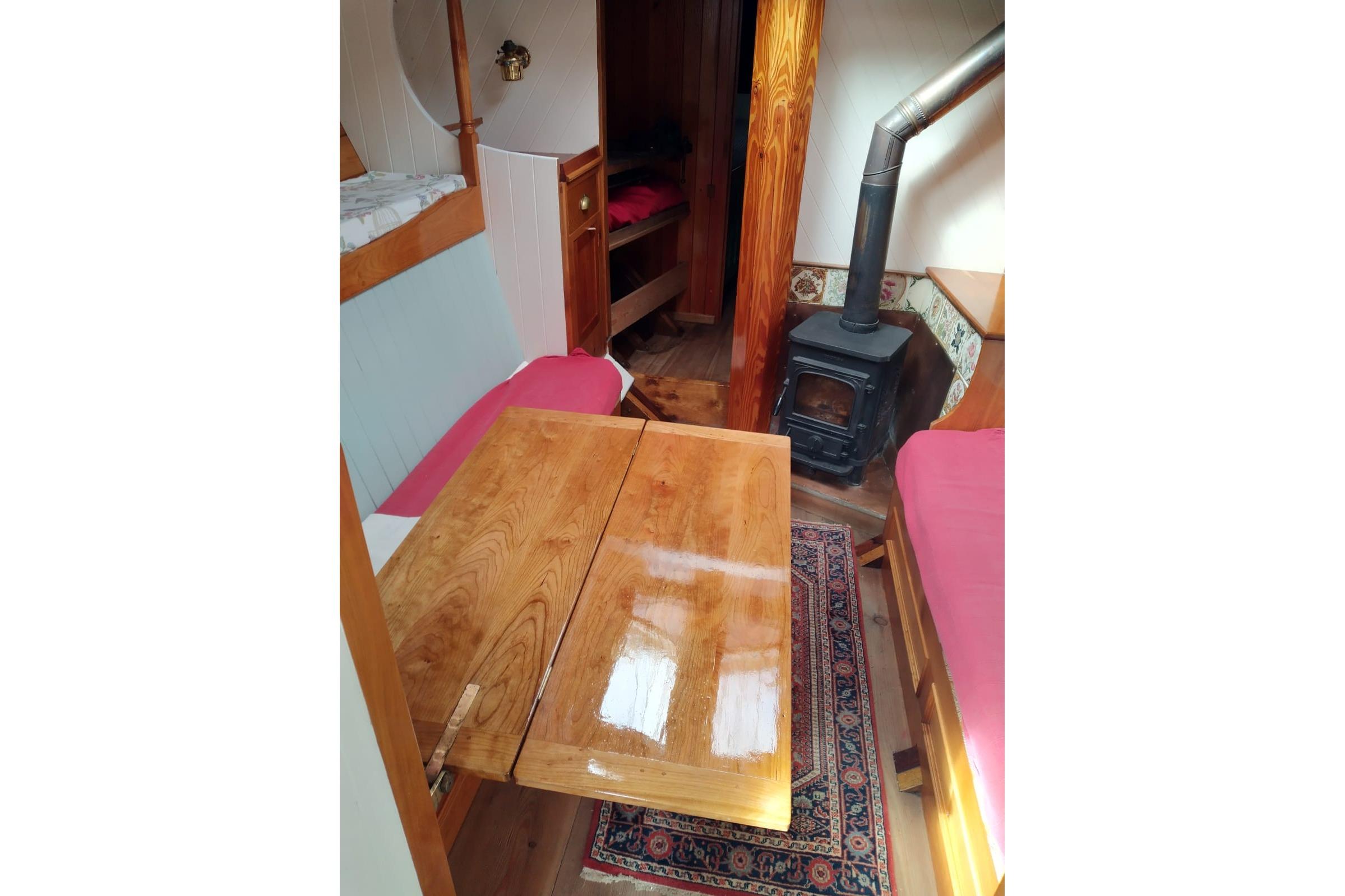 Cozy interior of 2012 Custom Mayflower 50 boat with wood stove and dining area.