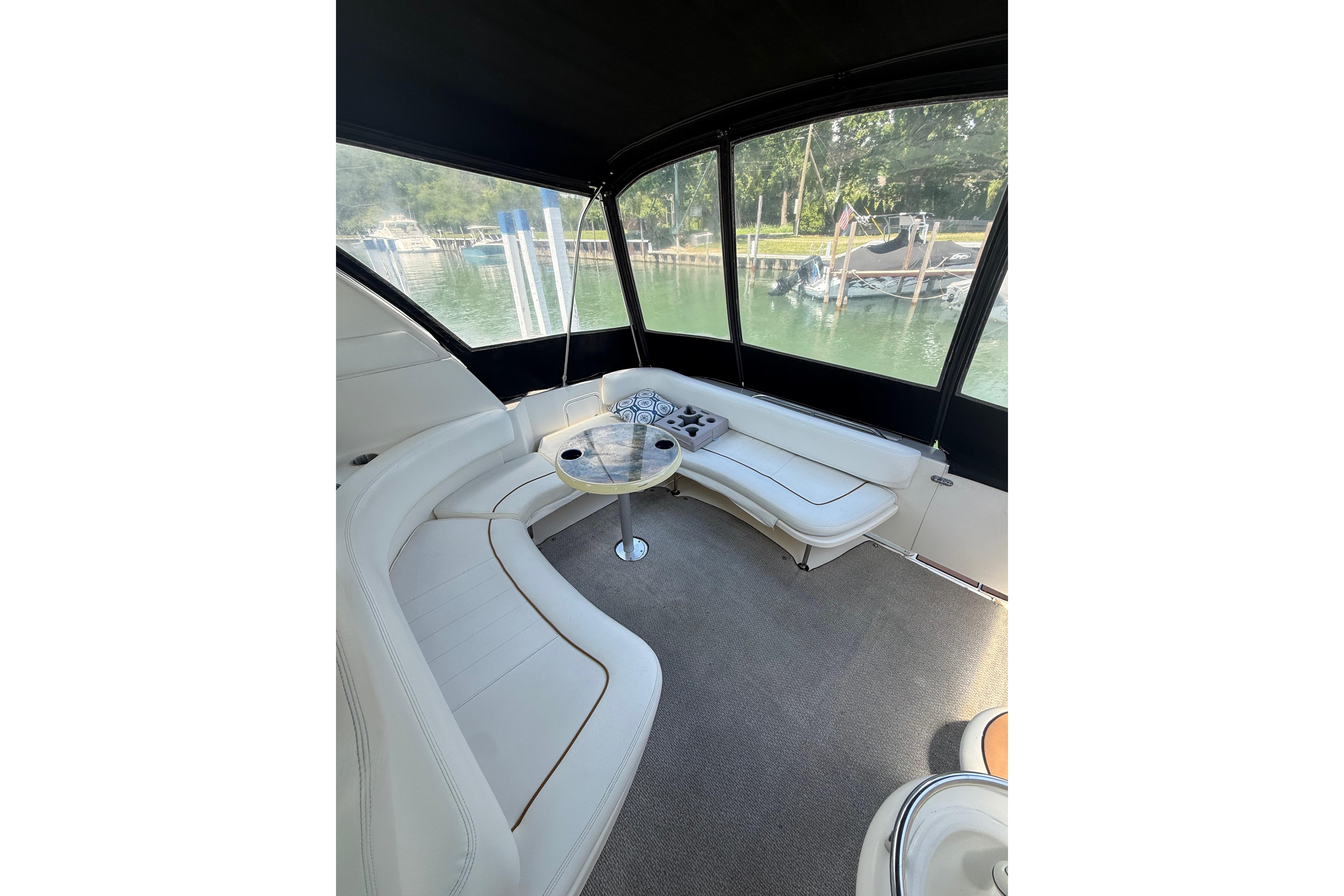 Interior of 1999 Sea Ray Sundancer 310 yacht with white seating and table.