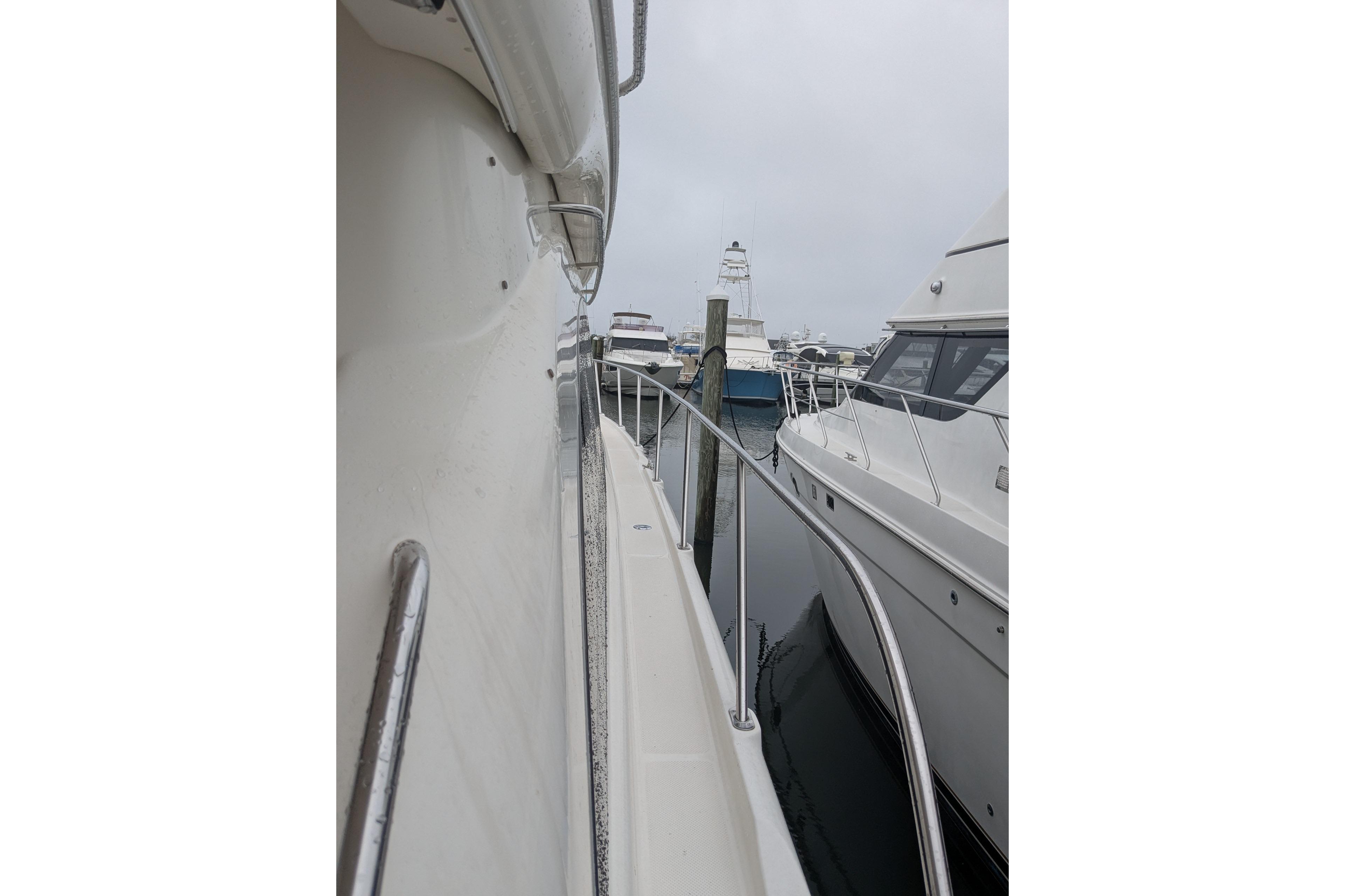 2004 Meridian 411 yacht docked in a marina, side view with railing.